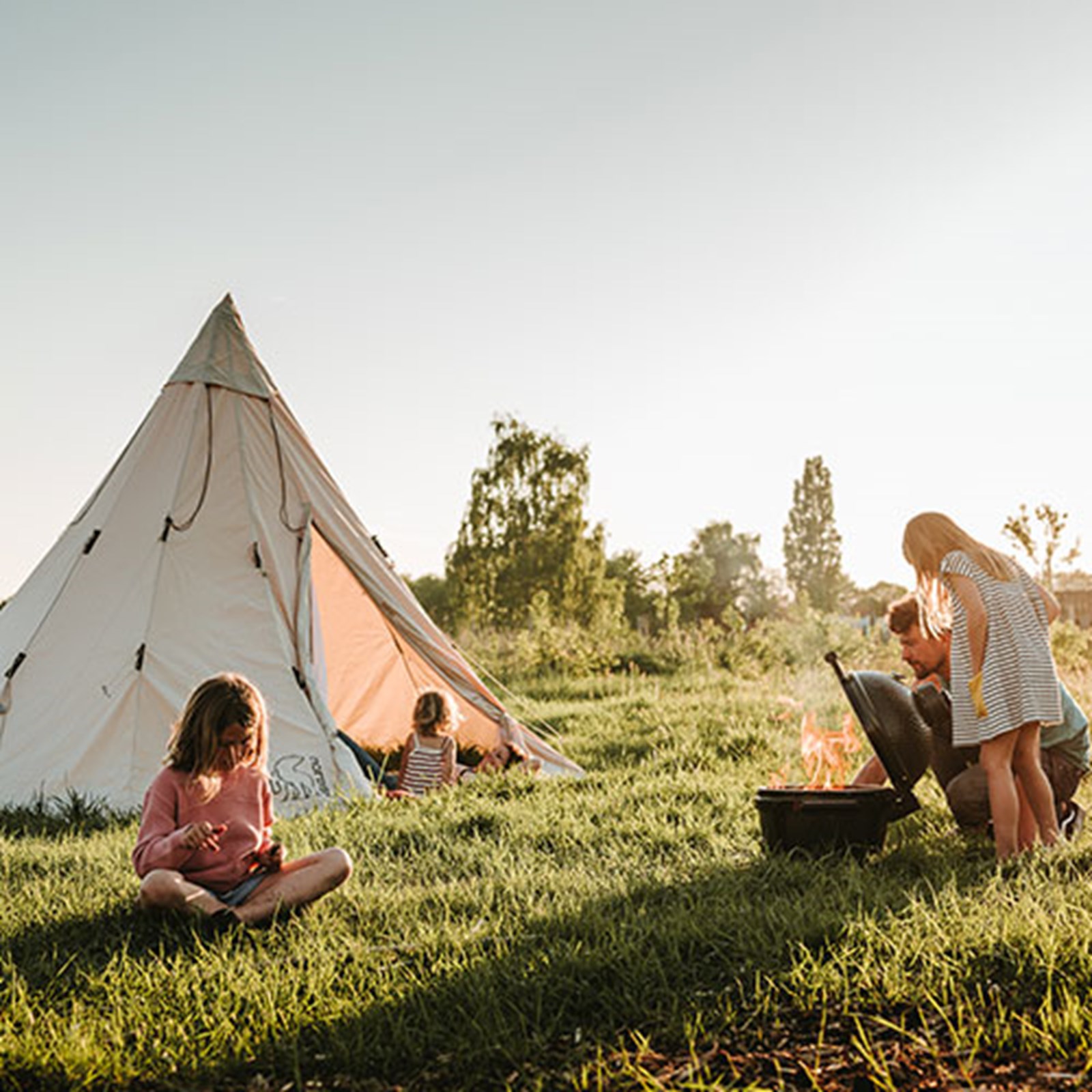 Familie der laver mad foran deres tipi-telt.