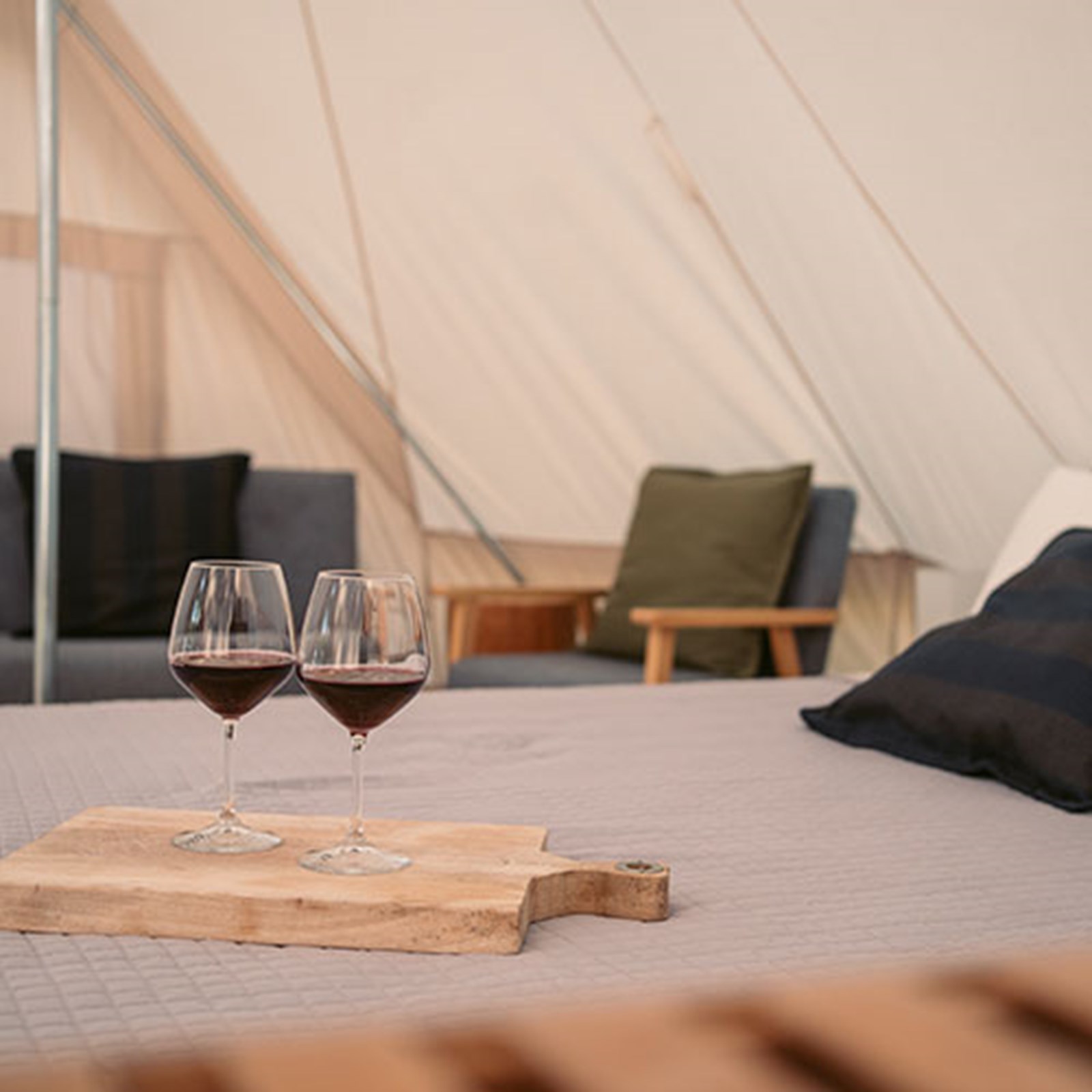 To glas vin inde i et glampingtelt.