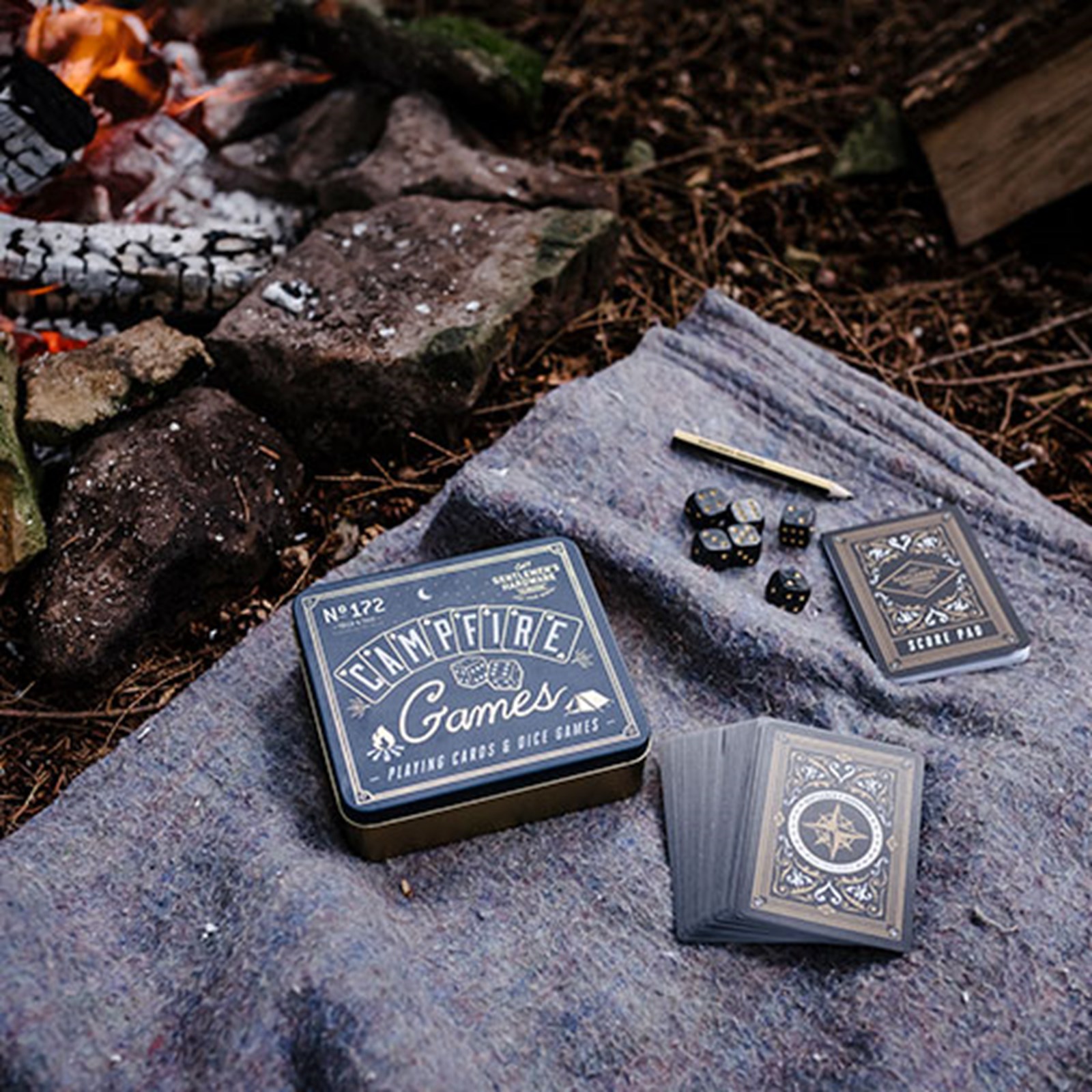 Kortspil og terninger ved et bål.