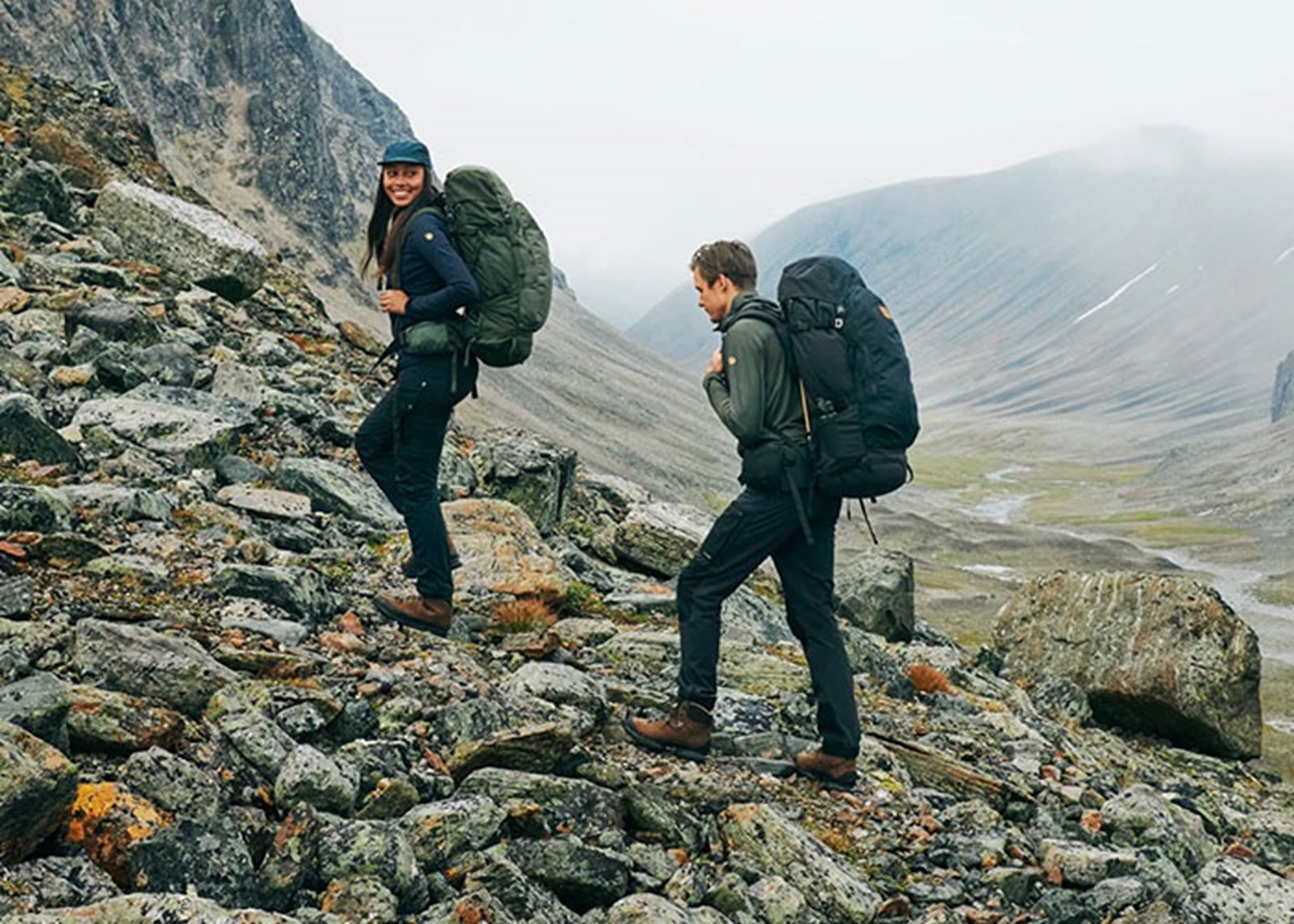 To personer på tur med Fjällräven tøj og rygsække.