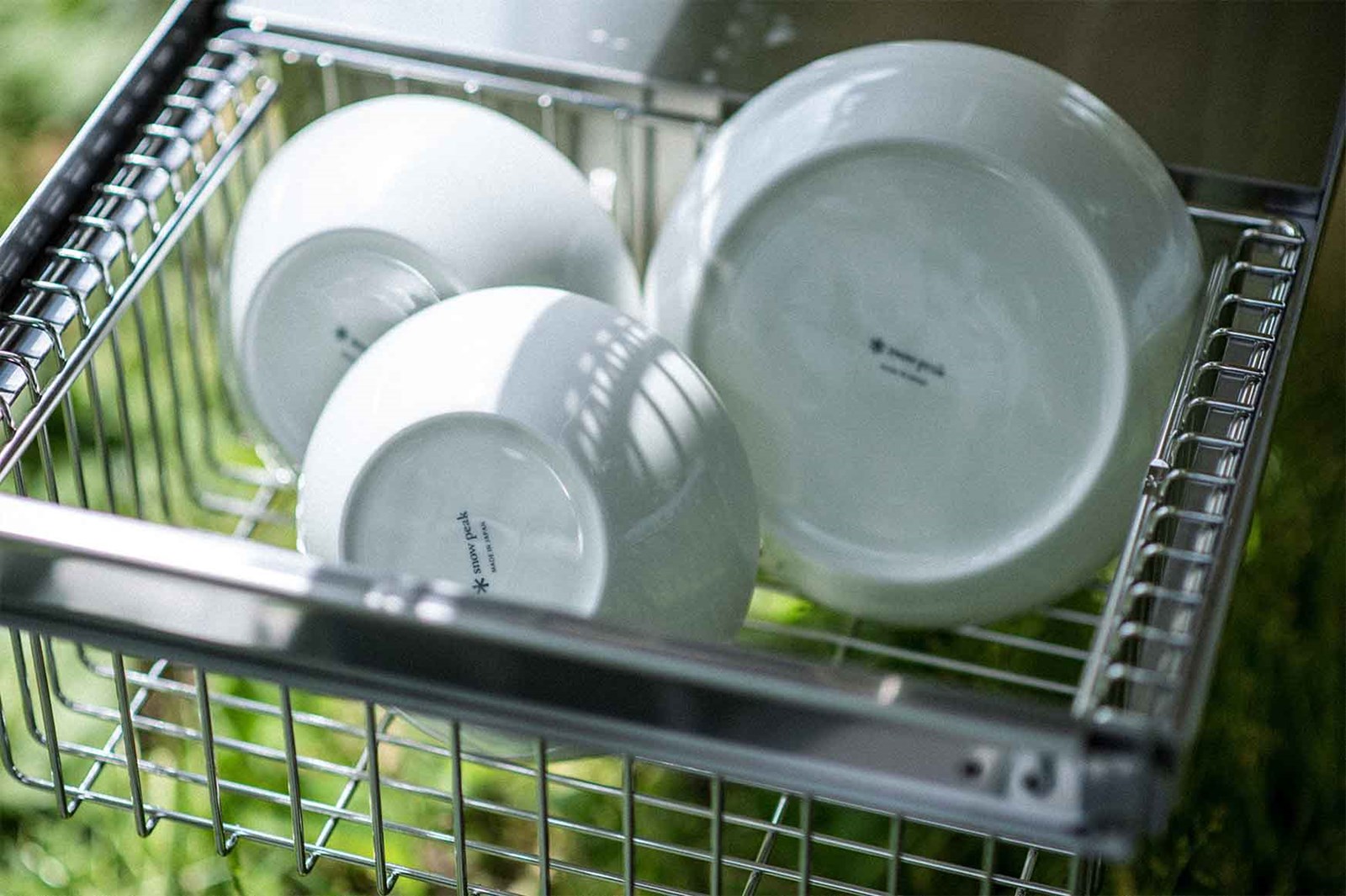 Tallerkner og skåle i en Snow Peak kurv, som er integreret i IGT bordet.