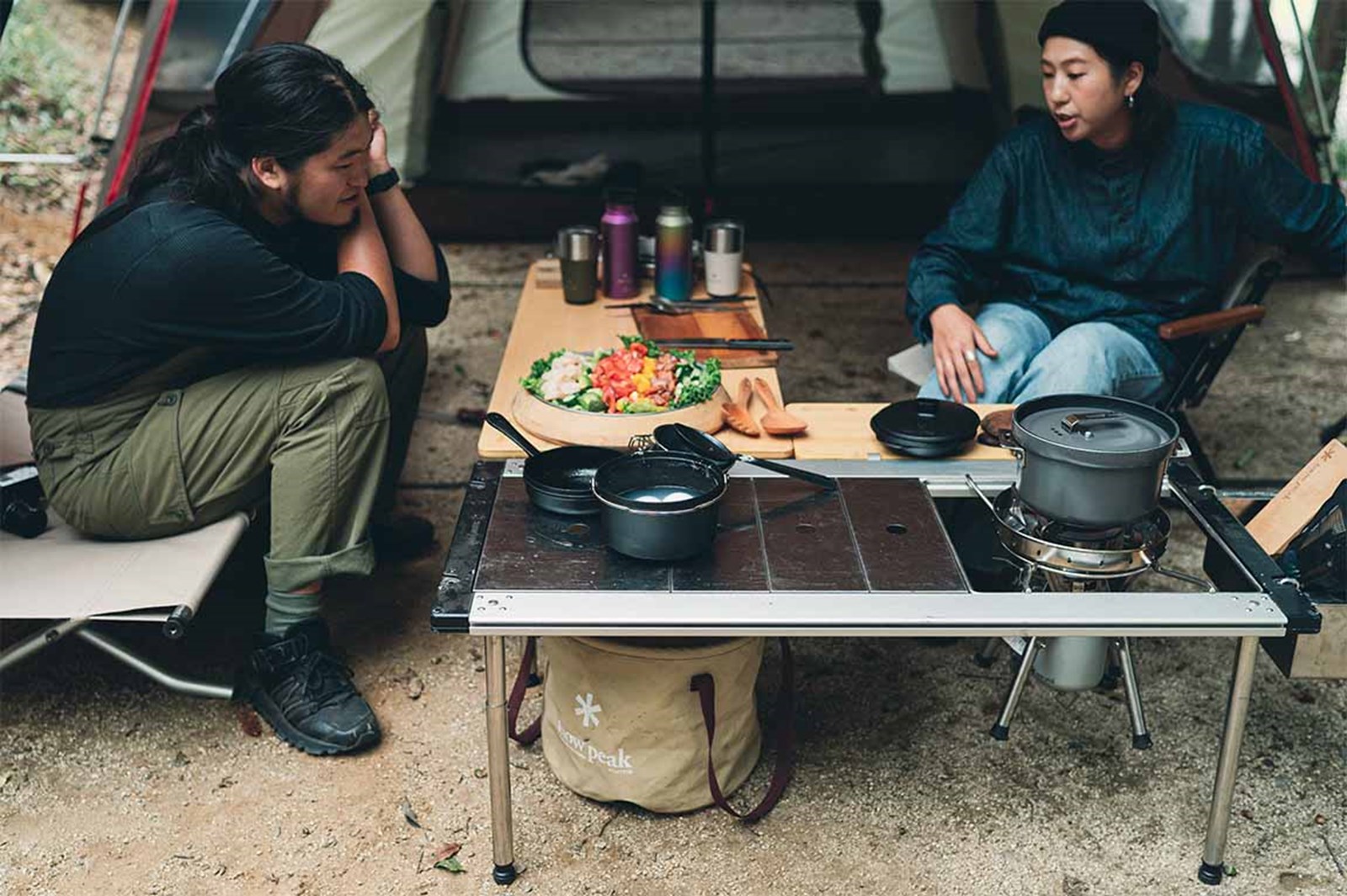To personer der hygger sig på teltur med madlavning ved IGT bordet.