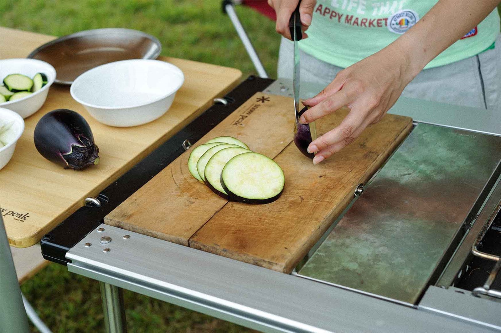 Snow peaks Chopping board der er integreret i IGT bordet og bliver anvendt til at skære aubergine.