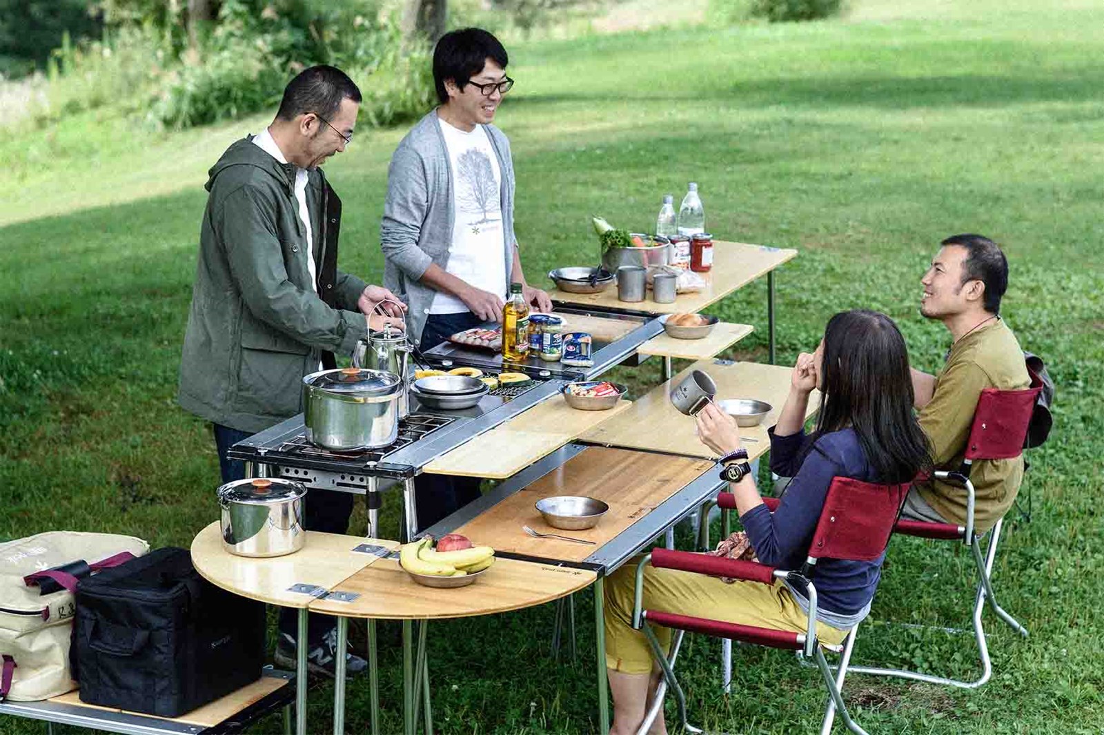 En flok mennekser tilbereder mad på et IGT bord, hvor der både er madlavningsstation og spiseplads.