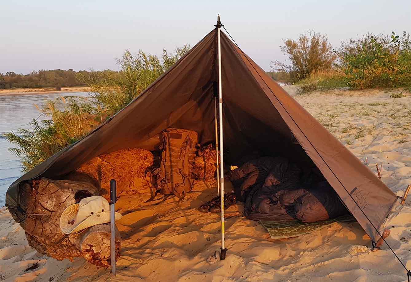 Tarp, der er sat op på stranden med en teltstang.