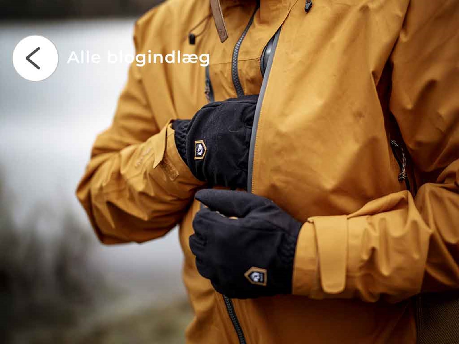 Mand iført gul jakke og sorte handsker