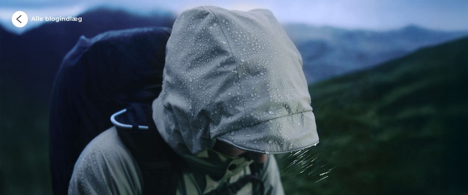 Person i bjergene med skaltøj, der holder dem tør i regnvejret.