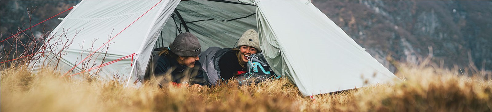 To personer ligger i et telt og griner.