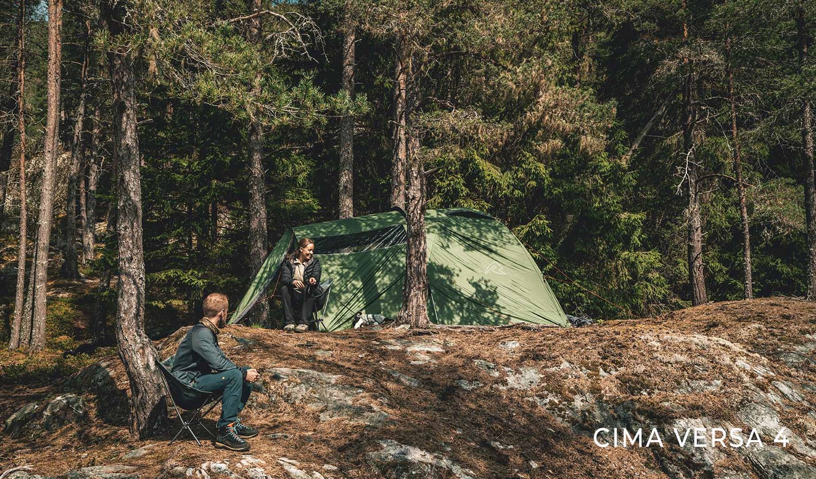 To mennesker nyder naturen og deres telt i skoven