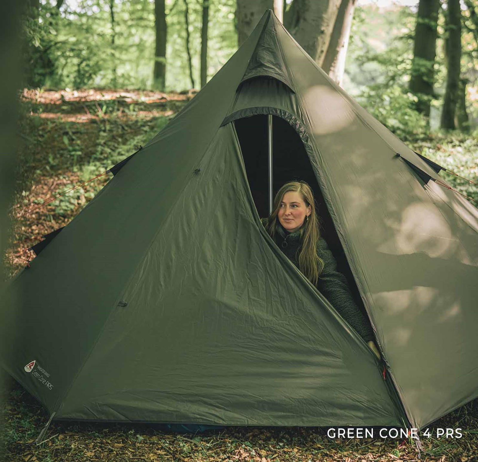 Kvinder kigger ud fra sit telt i skoven