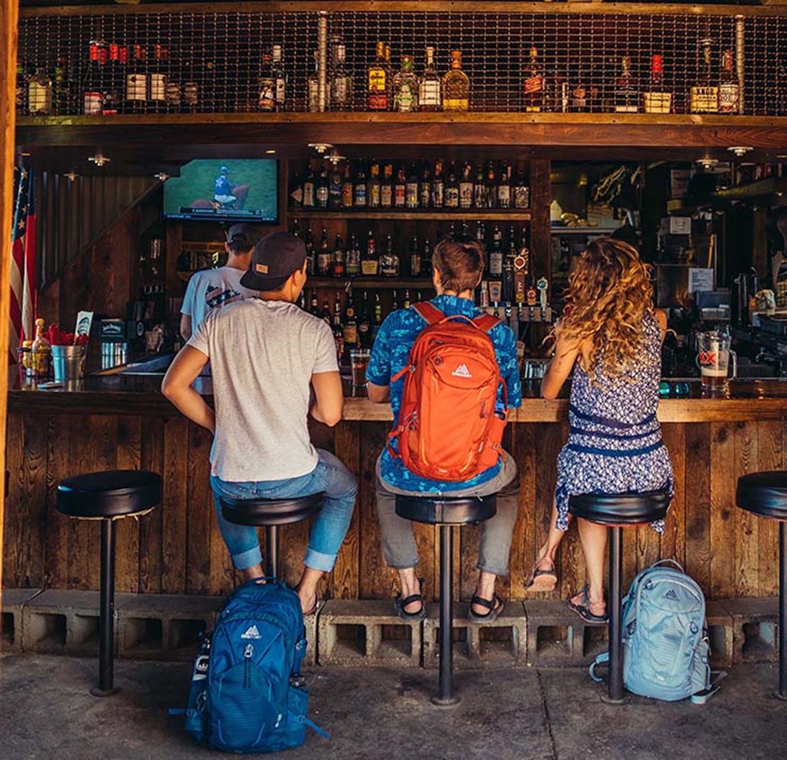 Tre backpackere sidder på et hostel i baren.