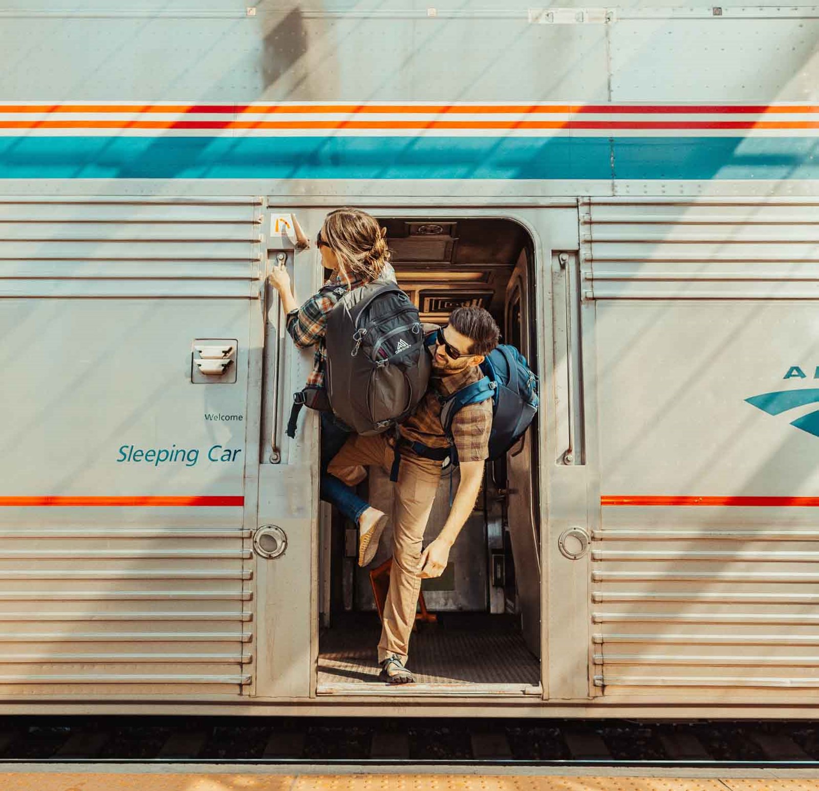 To personer der kigger ud af et tog.