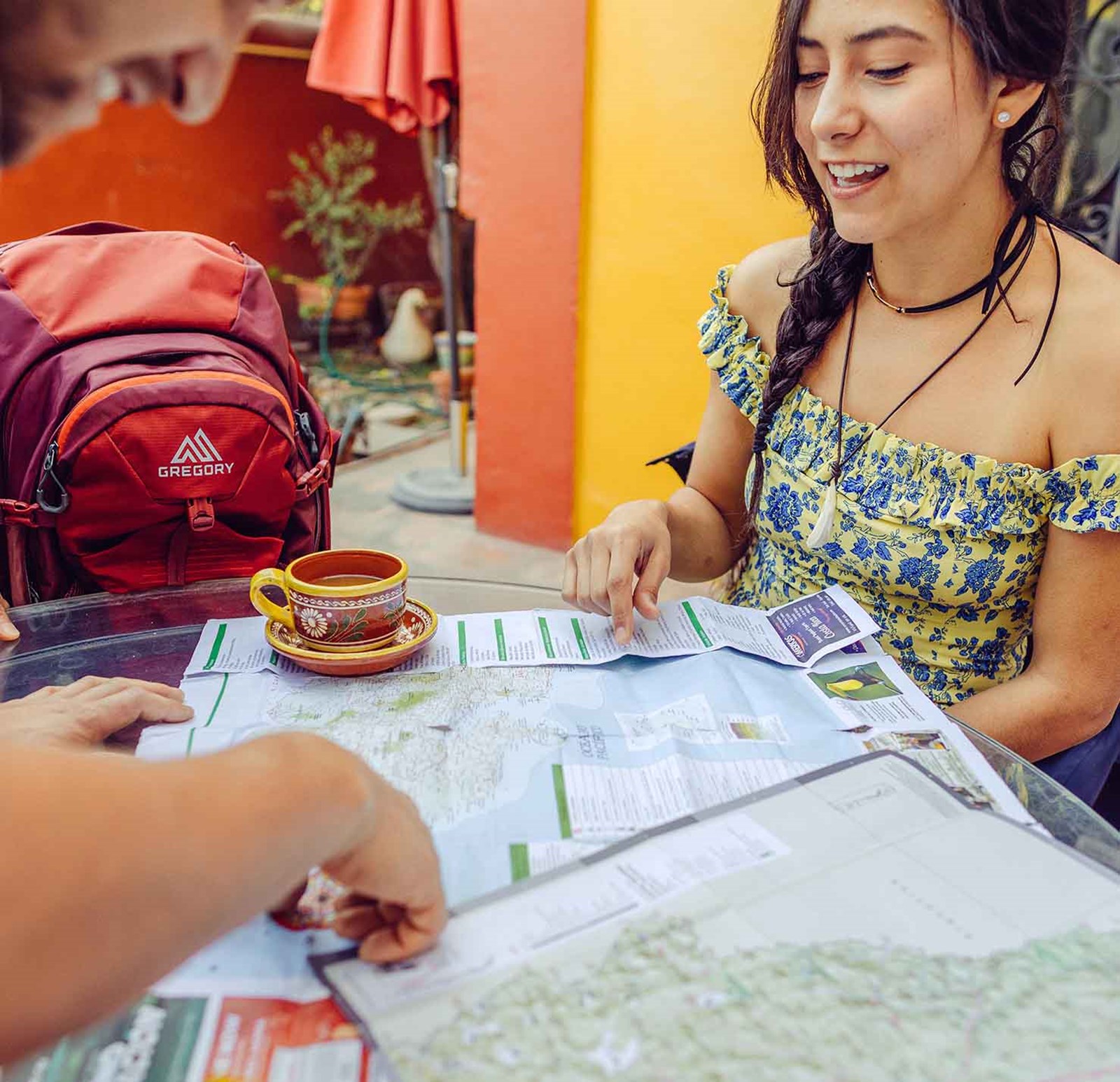 Personer der sidder og planlægger deres tur med kort og kaffe.