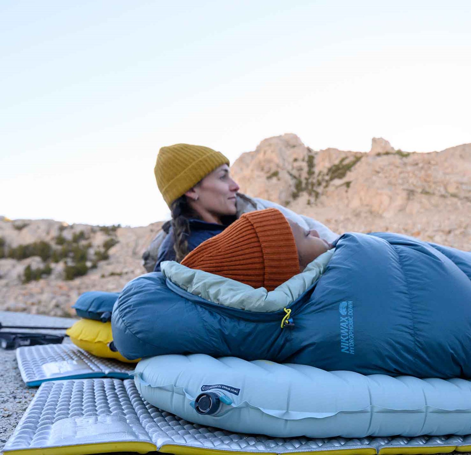 To personer, der ligger på deres liggeunderlag med et skumunderlag under.