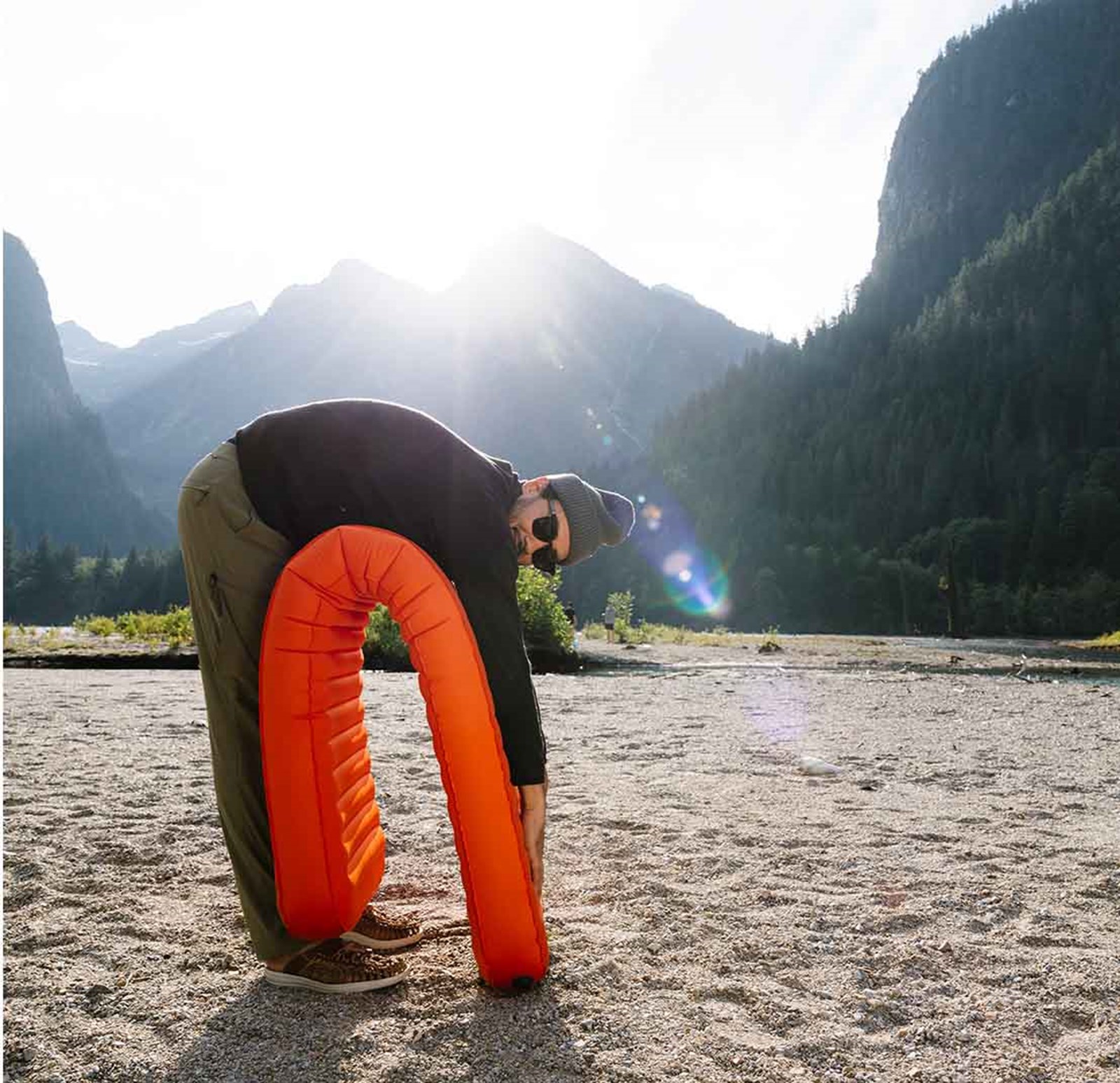 En mand der bukker sig ned med formen på sit liggeunderlag.