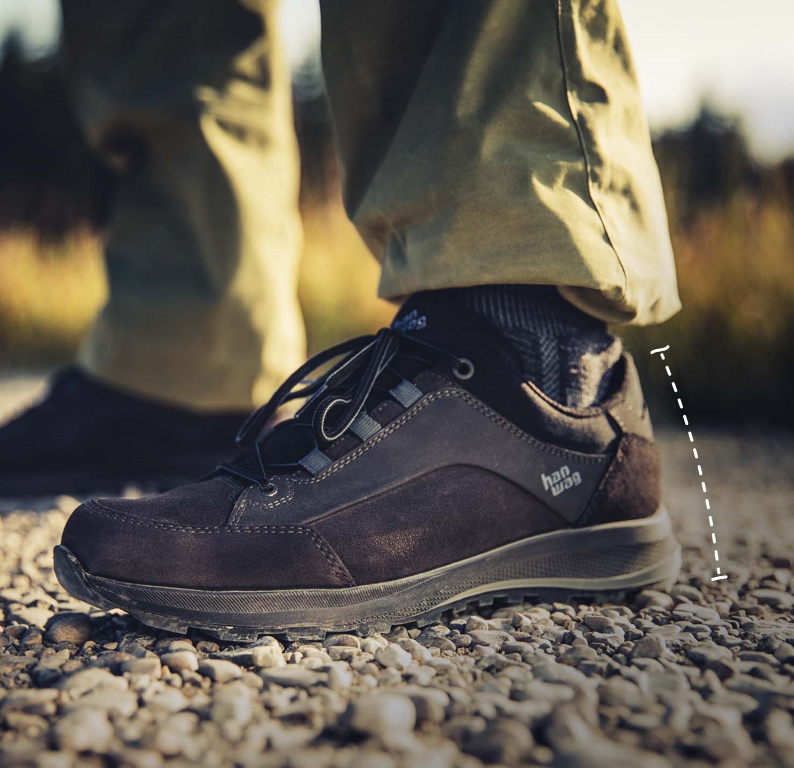 En lavskaftet vandresko, med en tegnet stiplet linje for at vise højden.