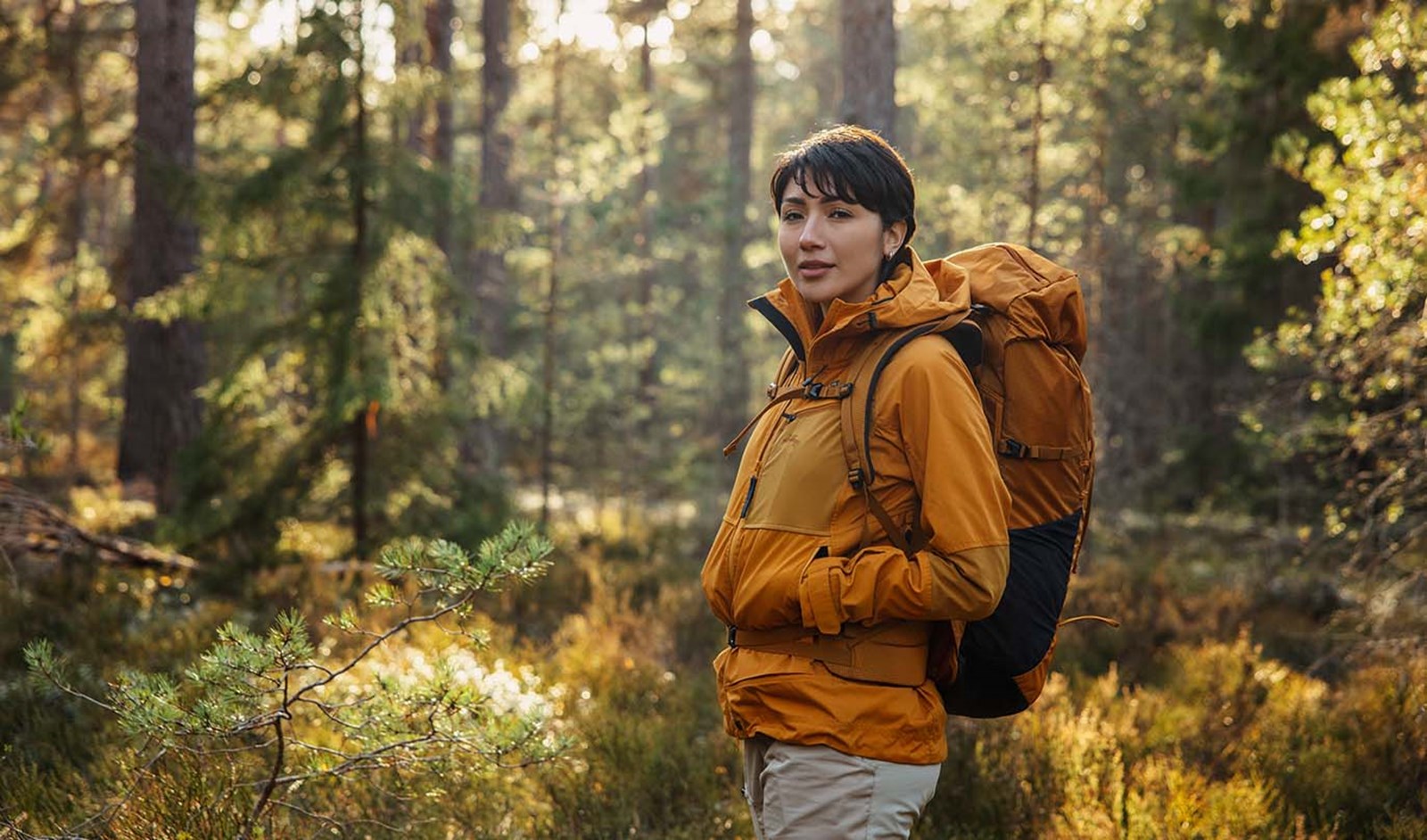 Person i skoven med rygsæk på.