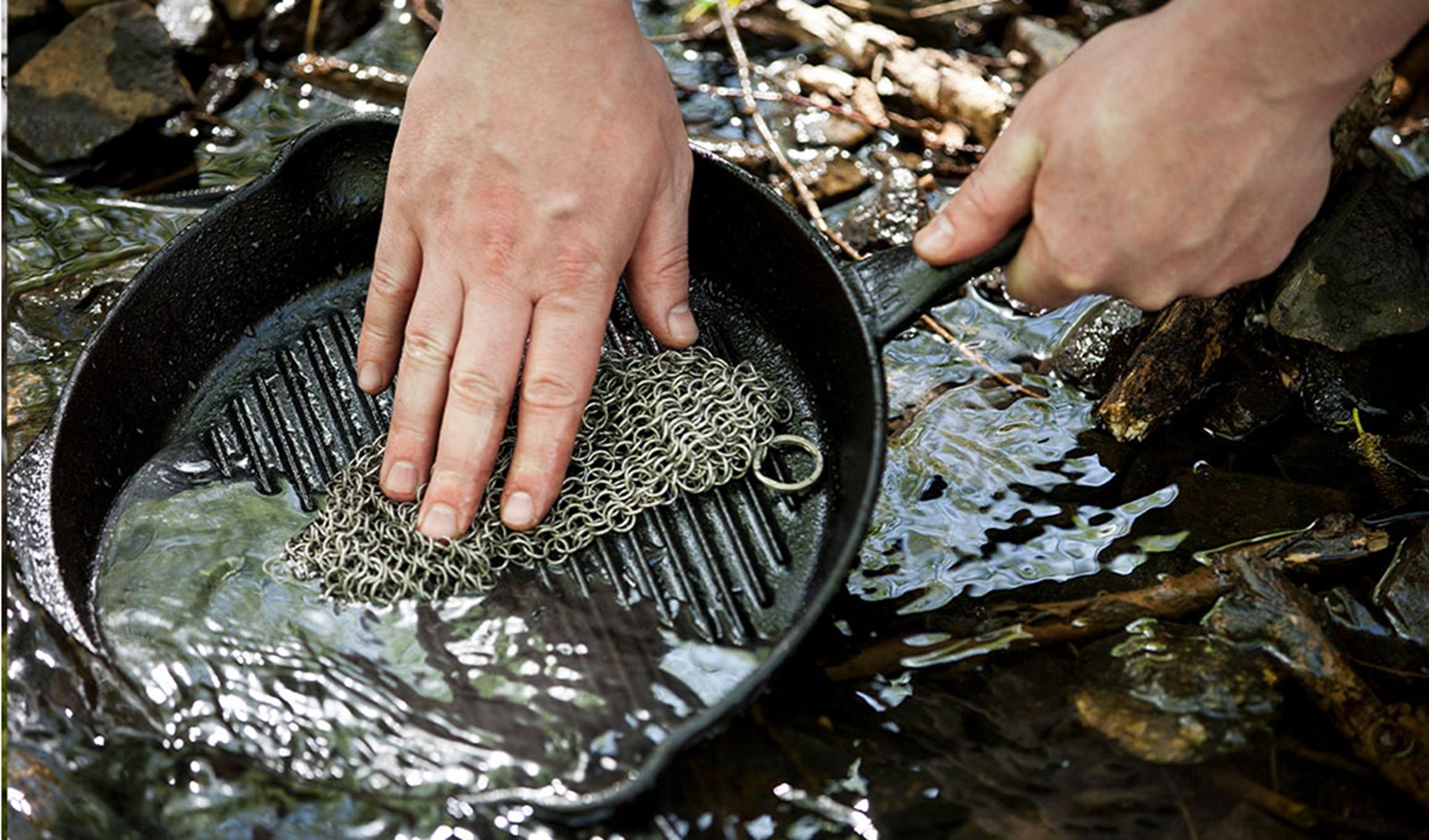 En person gør sin støbejernspande ren.