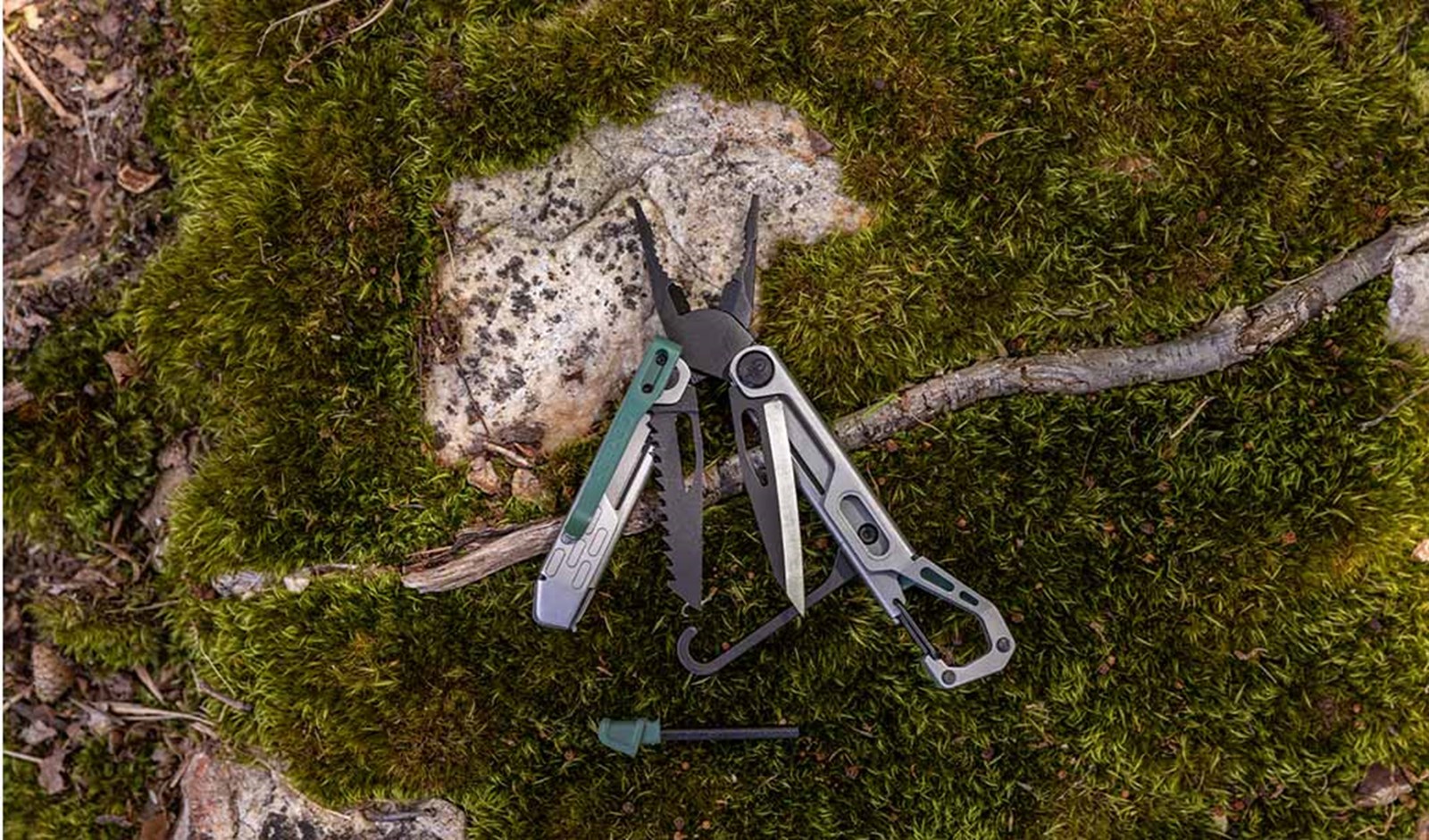 Gerber Stake Out Spark multiværktøj ligger foldet ud på mos.