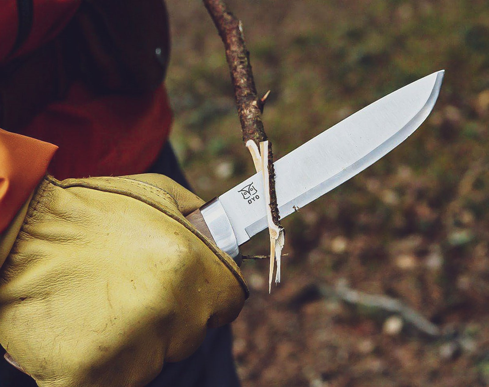 Øyo kniv der bruges til at snitte i træ, med handsker på.