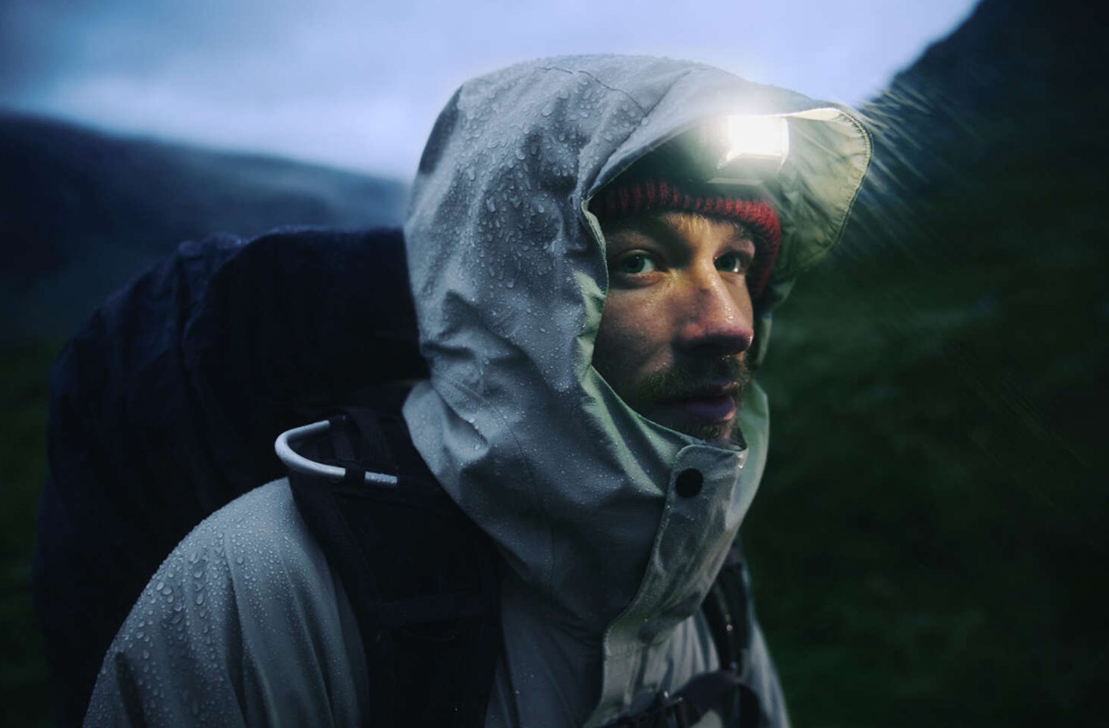 Mand i regnvejr med en skaljakke på.