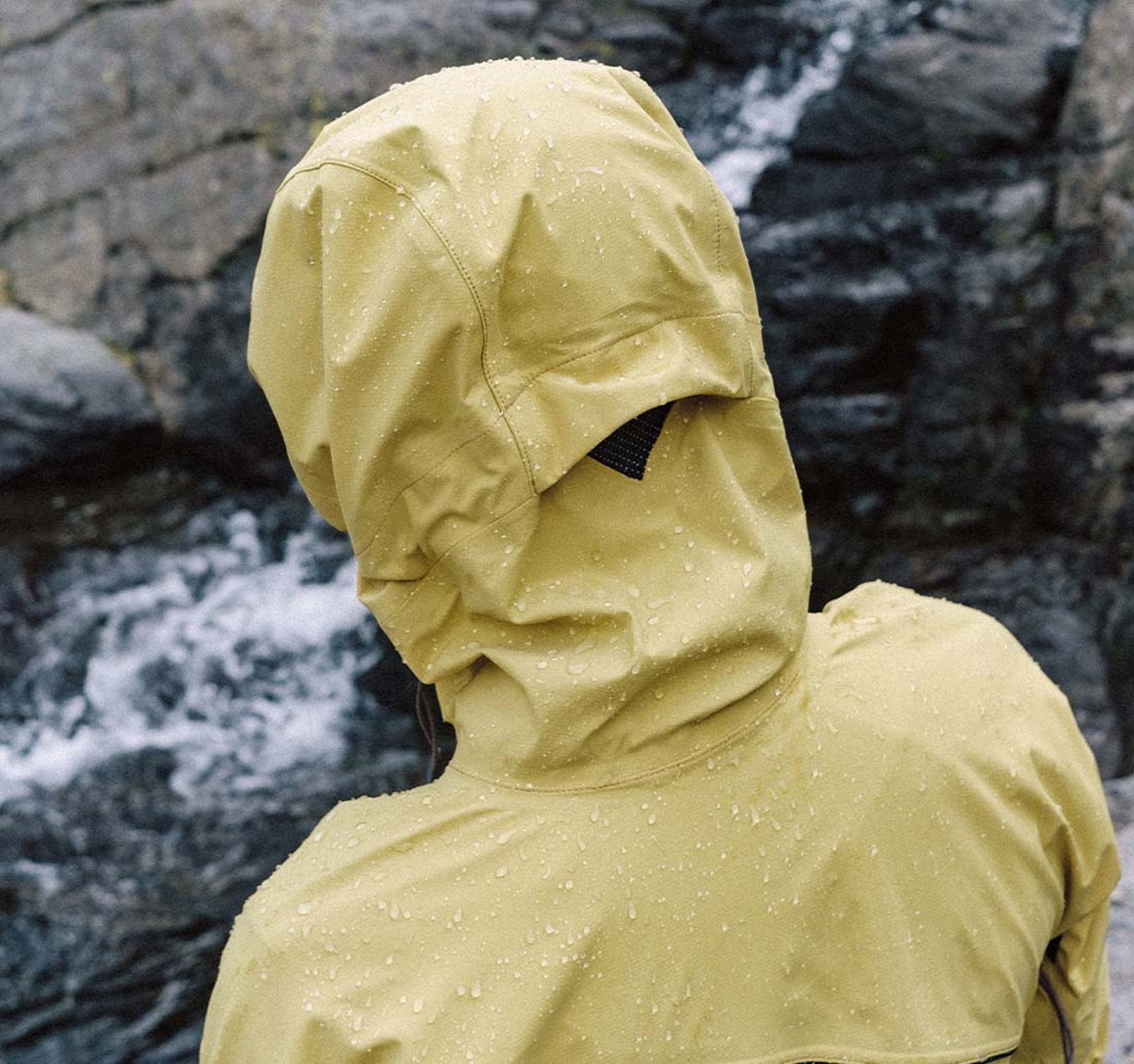 Person i Klättermusen skaljakke i regnvejr.