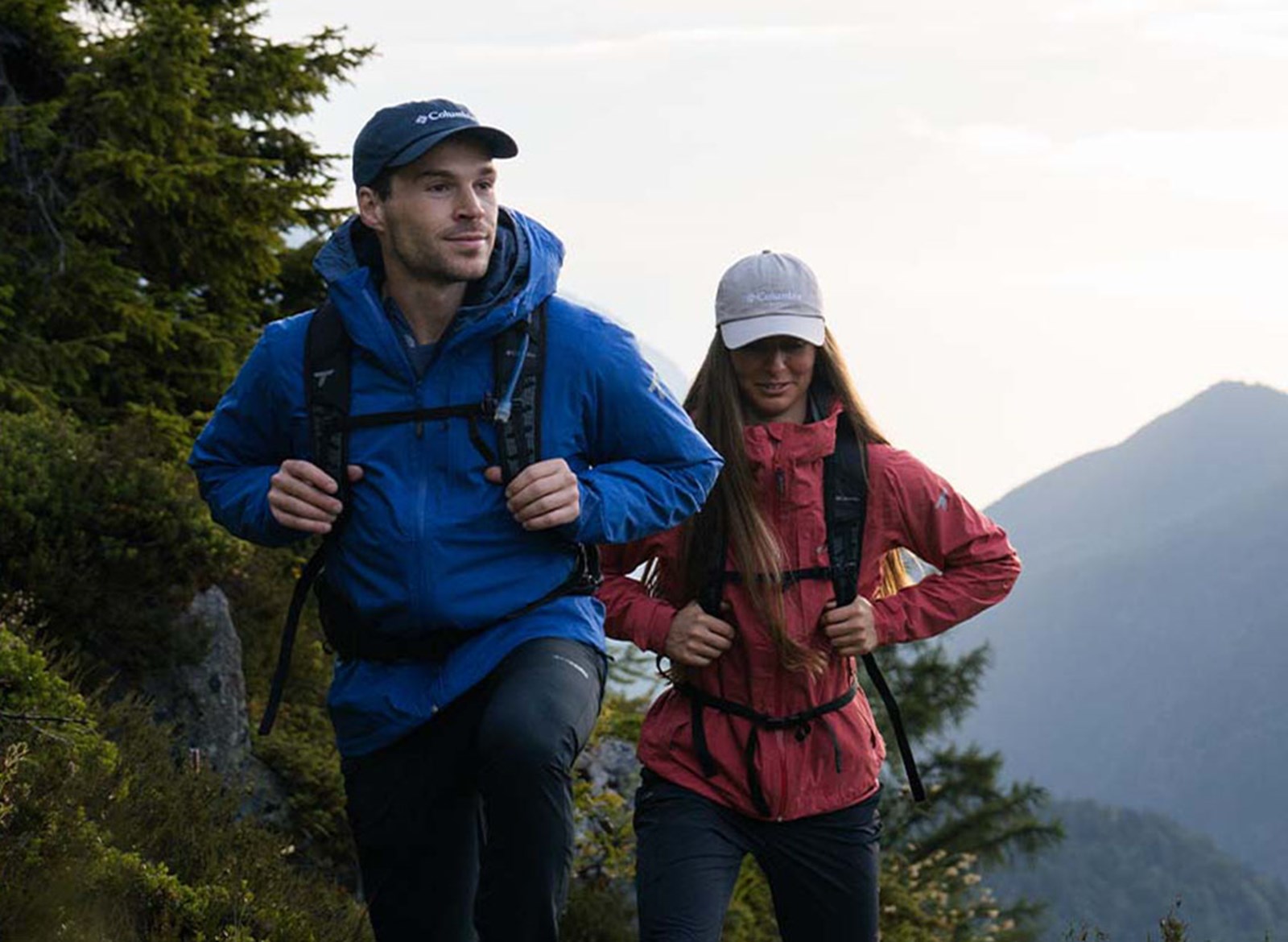 To mennesker på tur i deres skaljakker med rygsække.