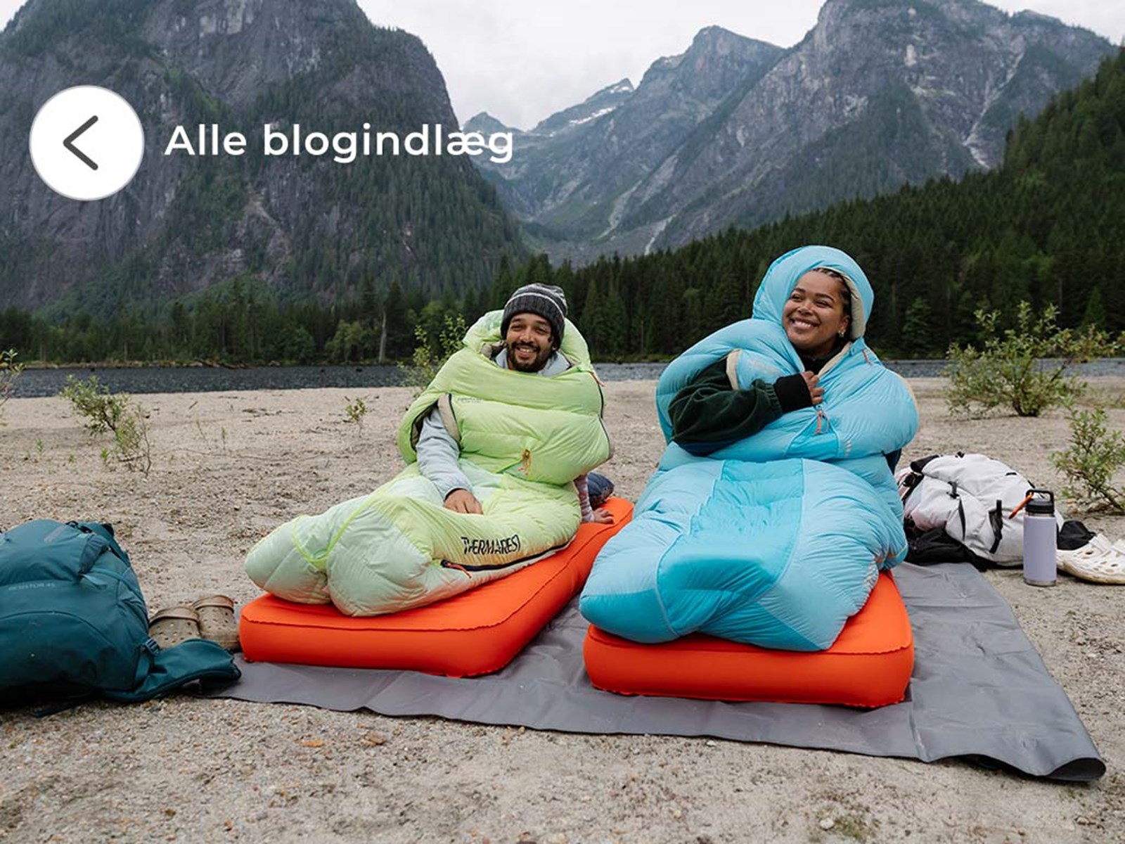 Par sidder i hver deres sovepose udenfor