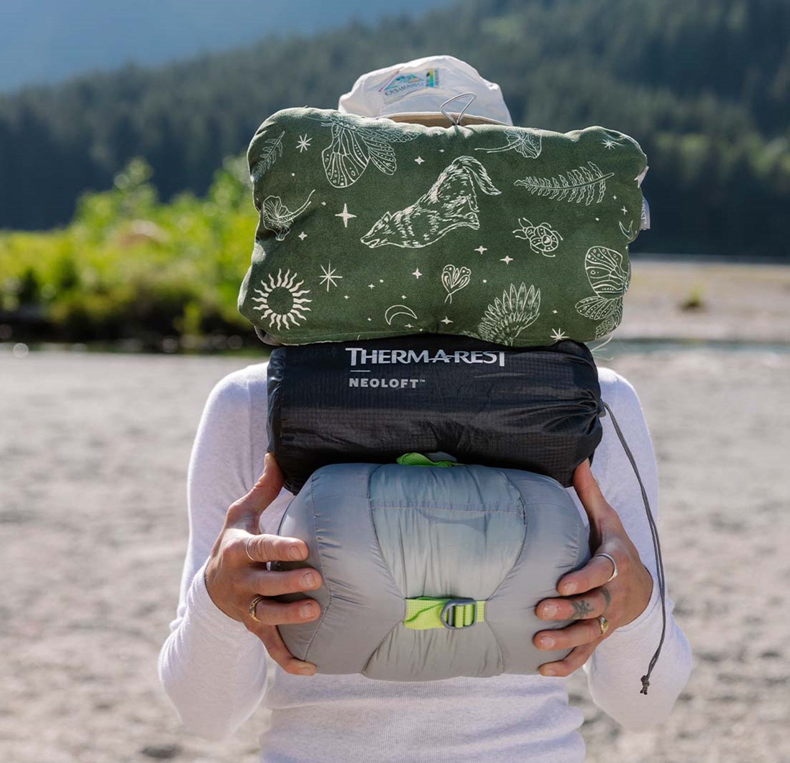 Kvinde der står med sovegrej fra Therm-a-rest.