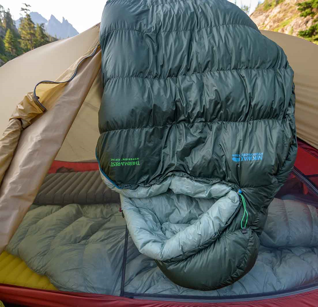 Sovepose der ligger oven på et telt og lufter