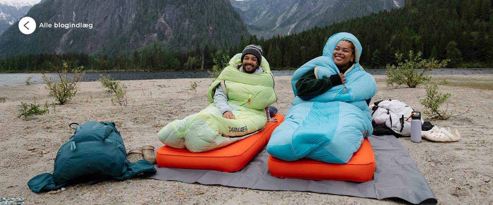 Par sidder i hver deres sovepose udenfor