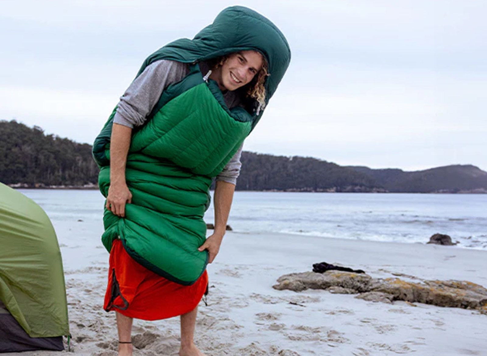 Person iført en sovepose, med åbent til fødderne.