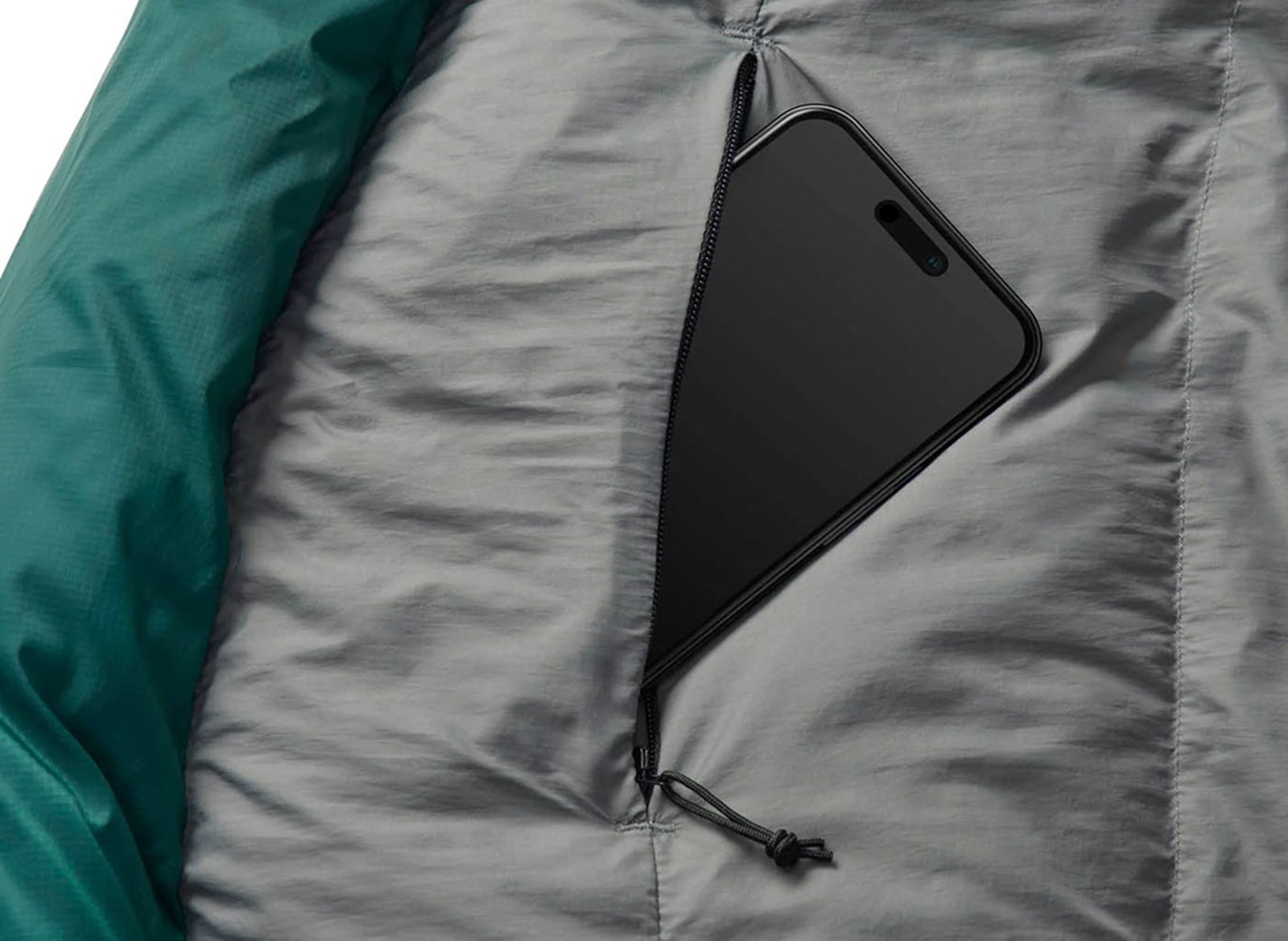 En mobil i en lomme på soveposen.