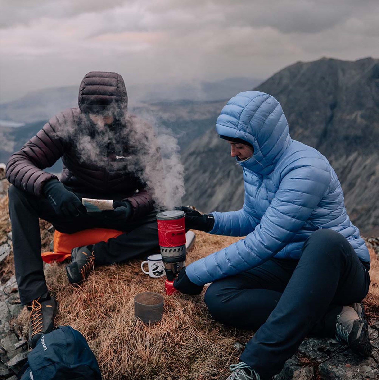 To personer der laver mad iført deres dunjakker.