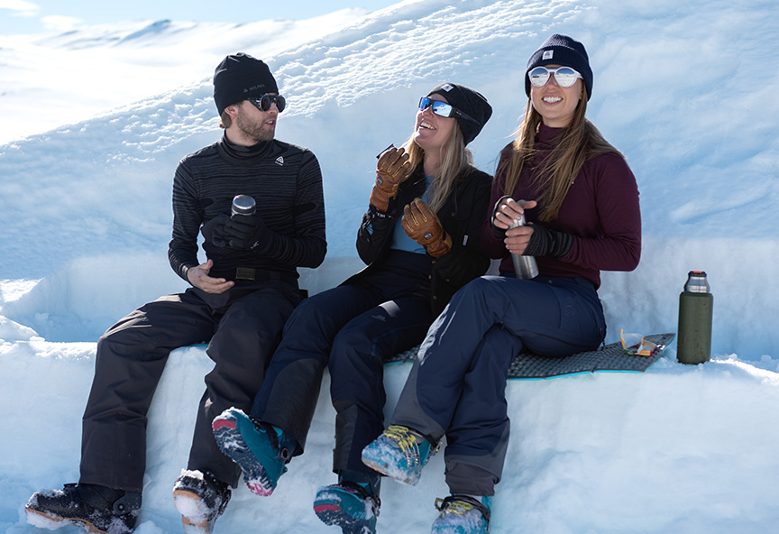 Venner der sidder og holder pause fra skiløb