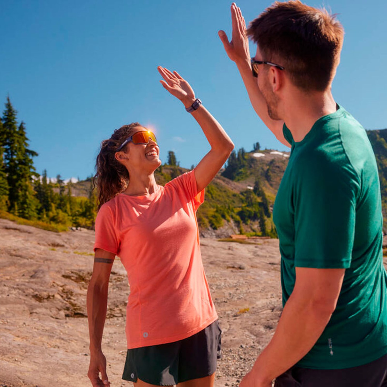 To mennesker der giver hinanden en highfive iført Smartwool tøj.