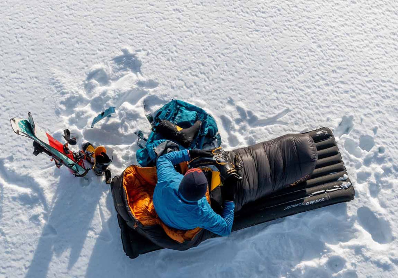 Person på et liggeunderlag i sneen.