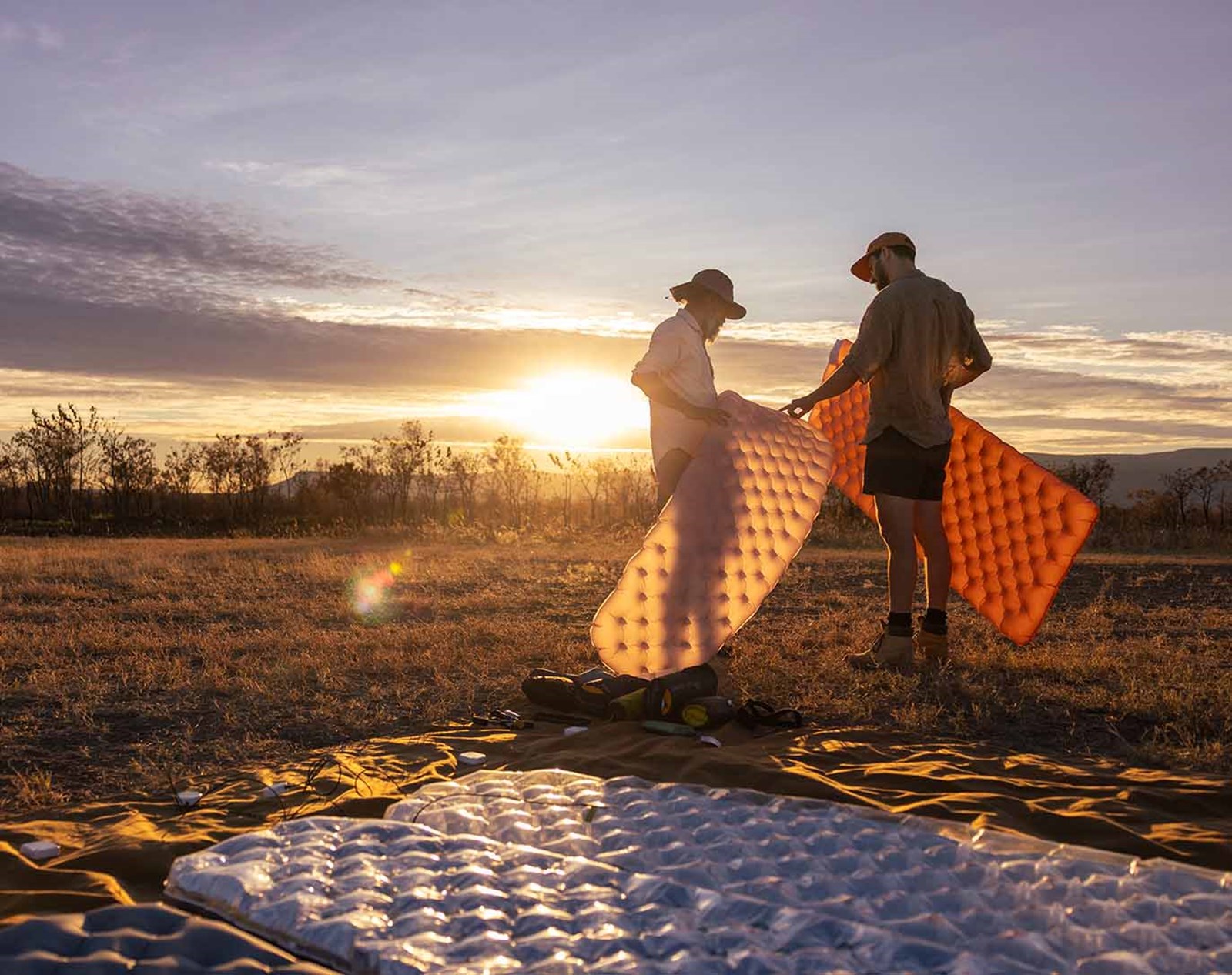 to personer kigger på liggeunderlag i solskin.