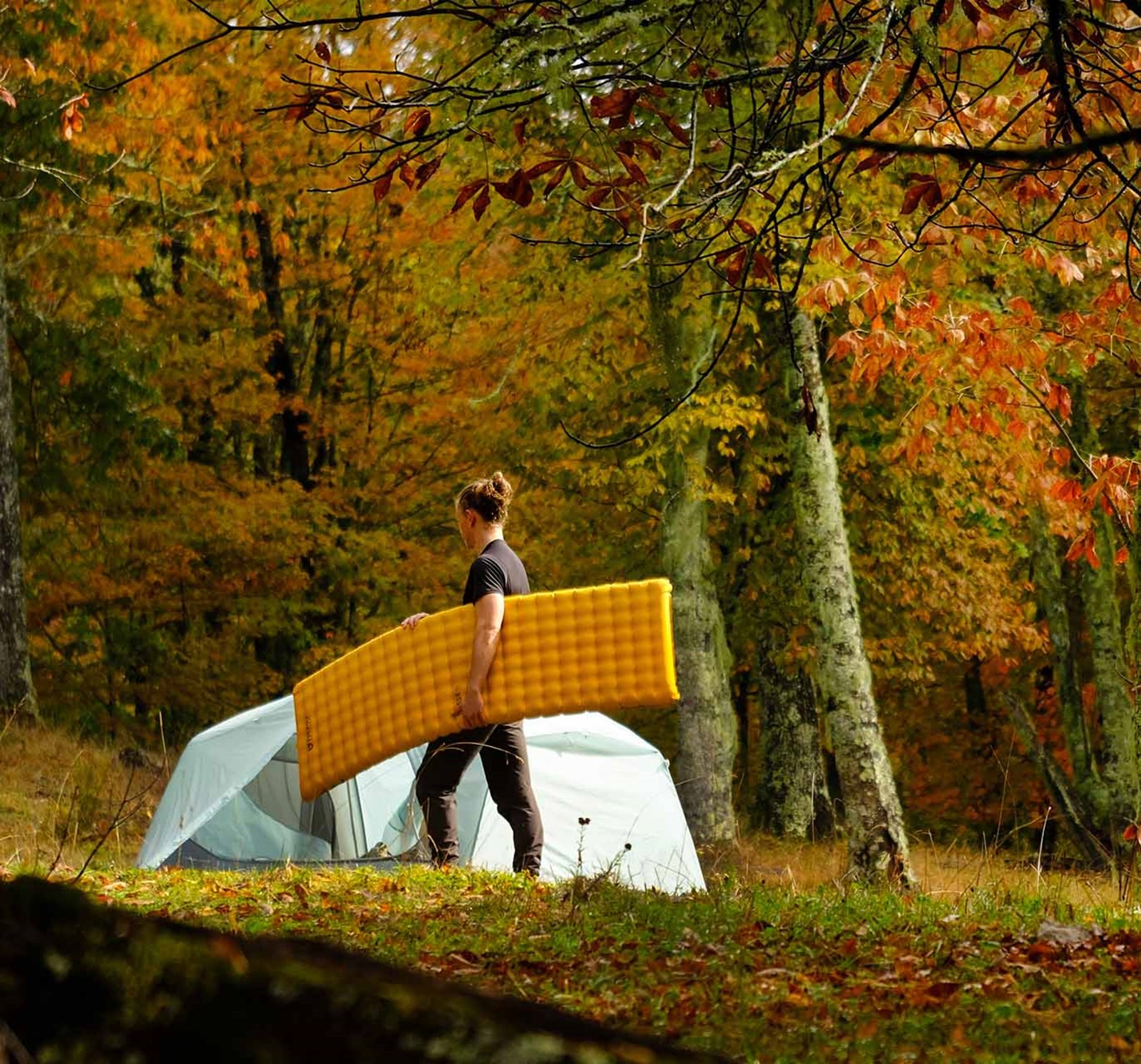 Mand i eftersårvejr står med sit Nemo liggeunderlag.