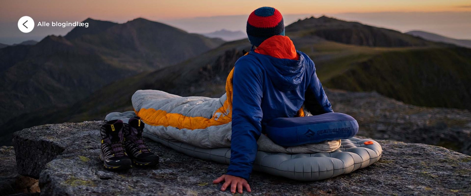 En person ligger på sit liggeunderlag på en bjergtop. Se alle blogindlæg her.