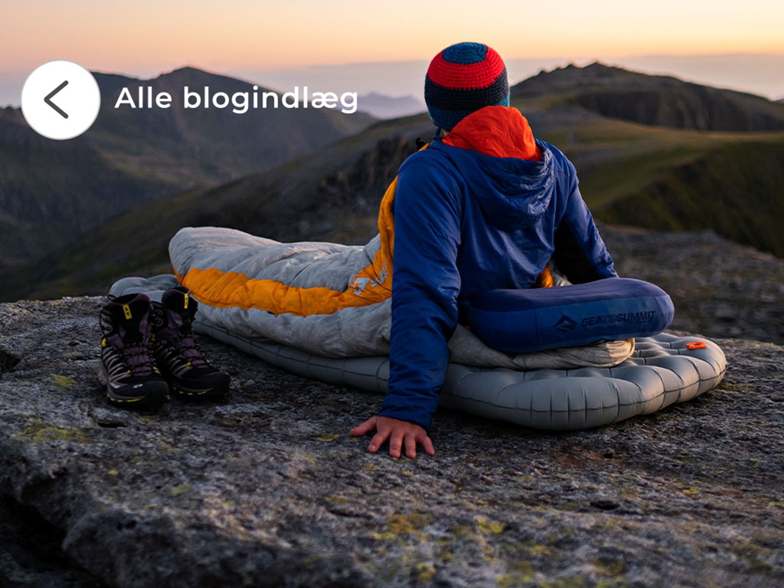 En person ligger på sit liggeunderlag på en bjergtop. Se alle blogindlæg her.