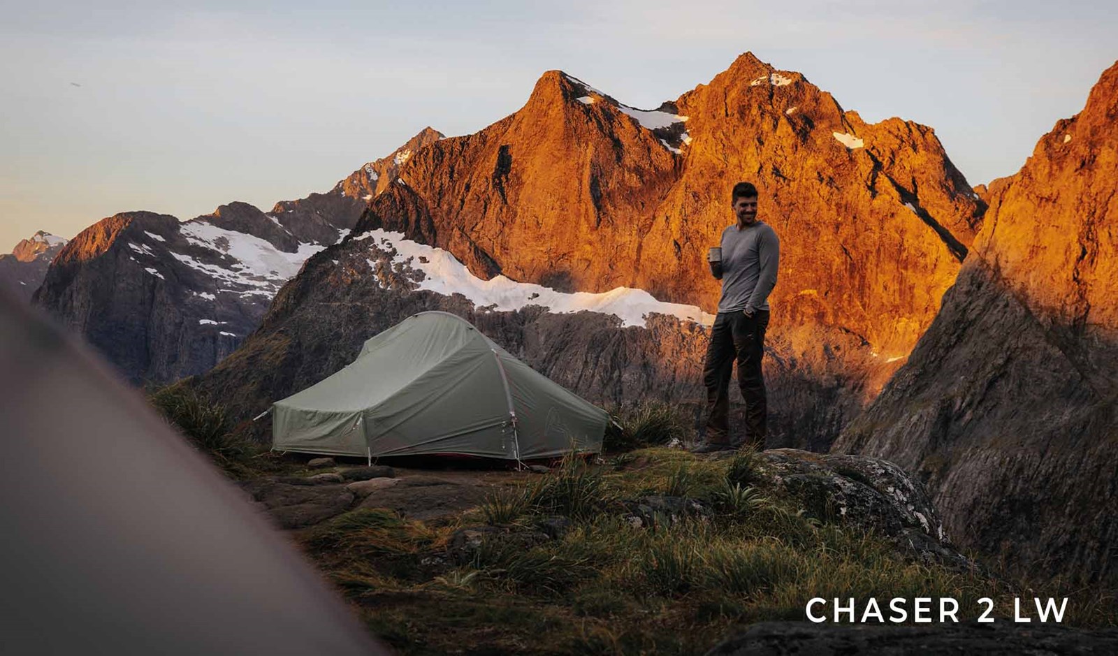 En mand på toppen af et bjerg, ved siden at sit Robens Chaser 2 LW telt.