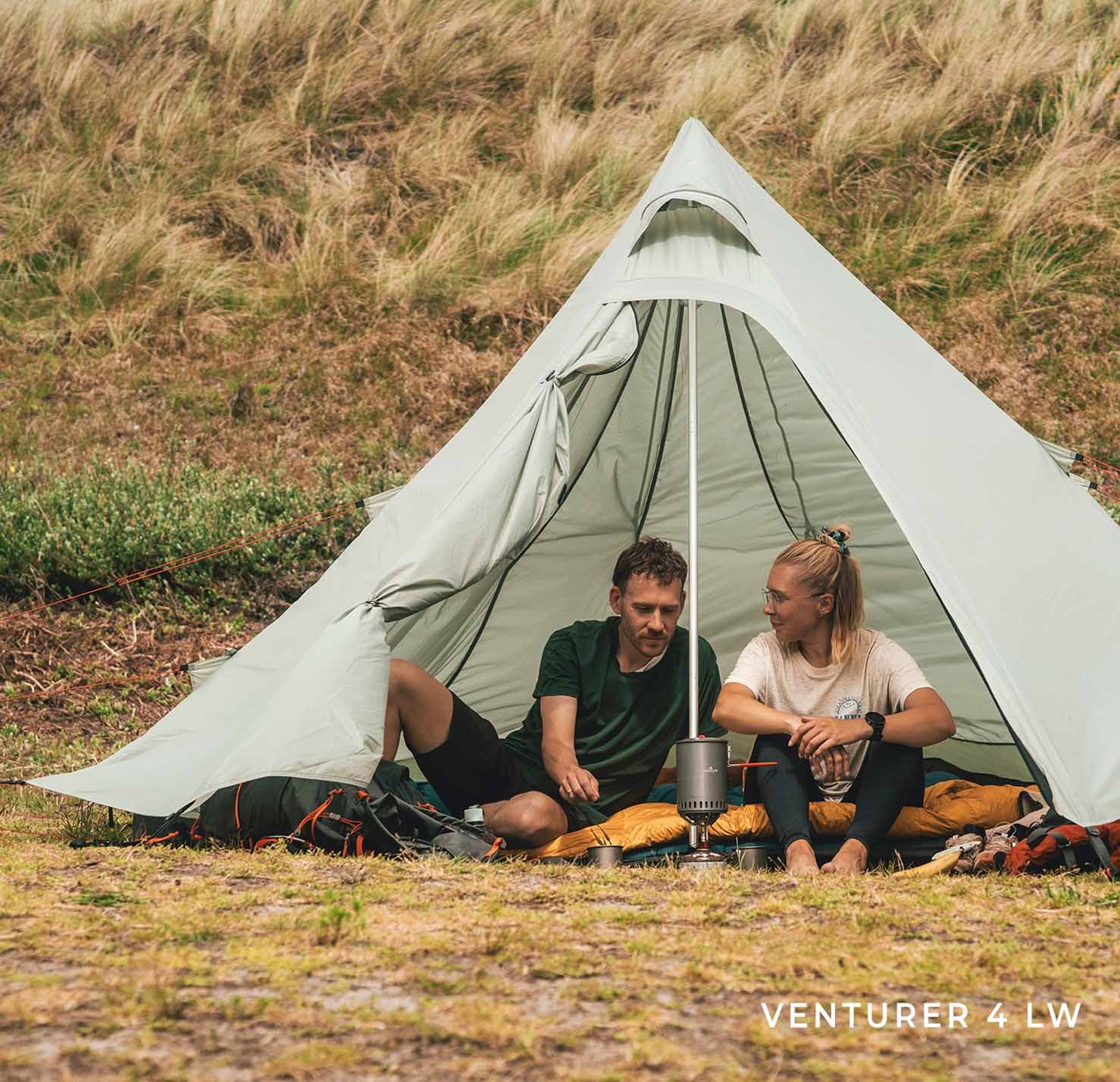 To personer i et Venturer telt fra Robens Lightweight range, og laver mad.