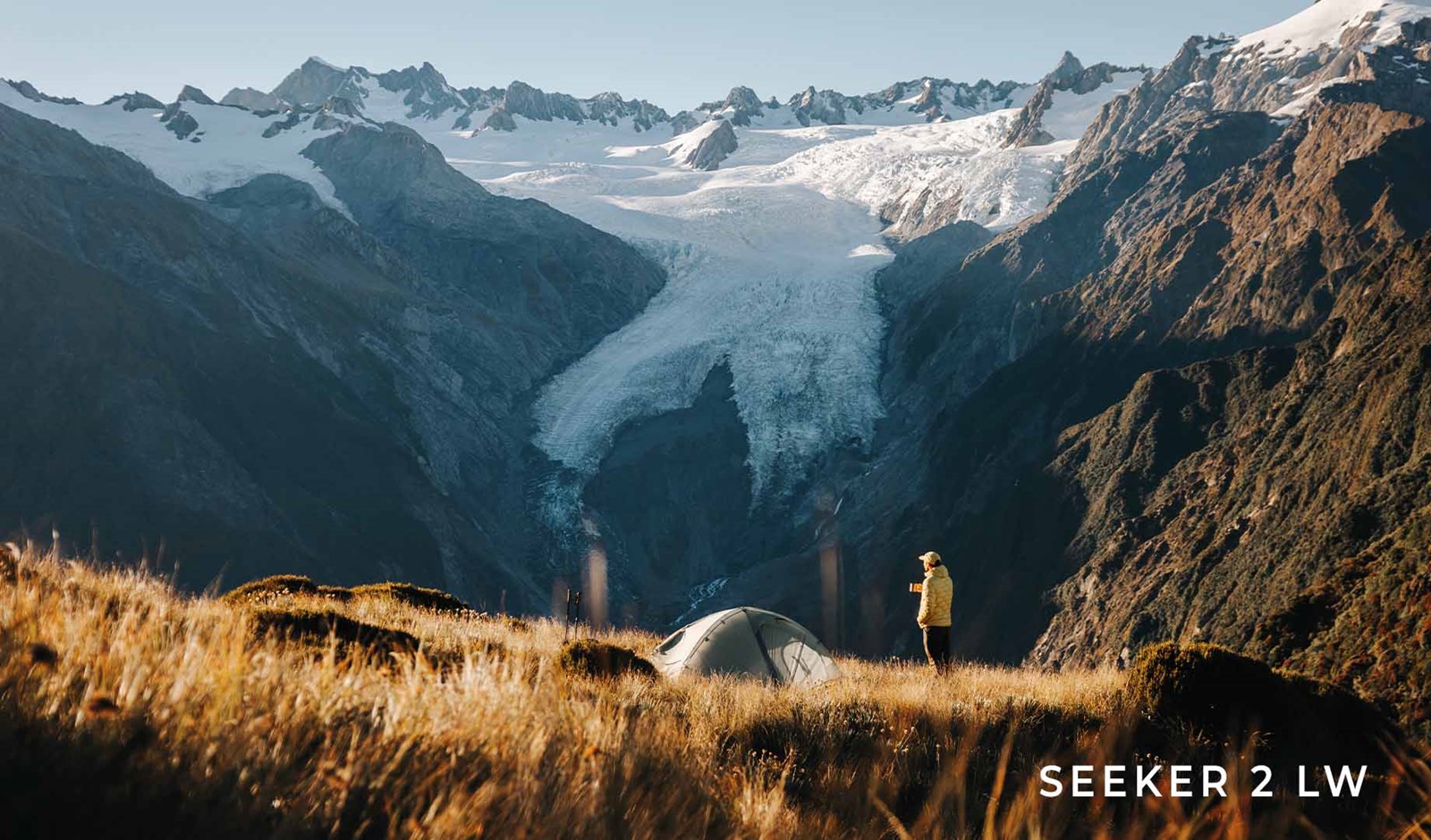 Mand med Seeker 2 LW på fjeldet med udsigt til en gletsjer.