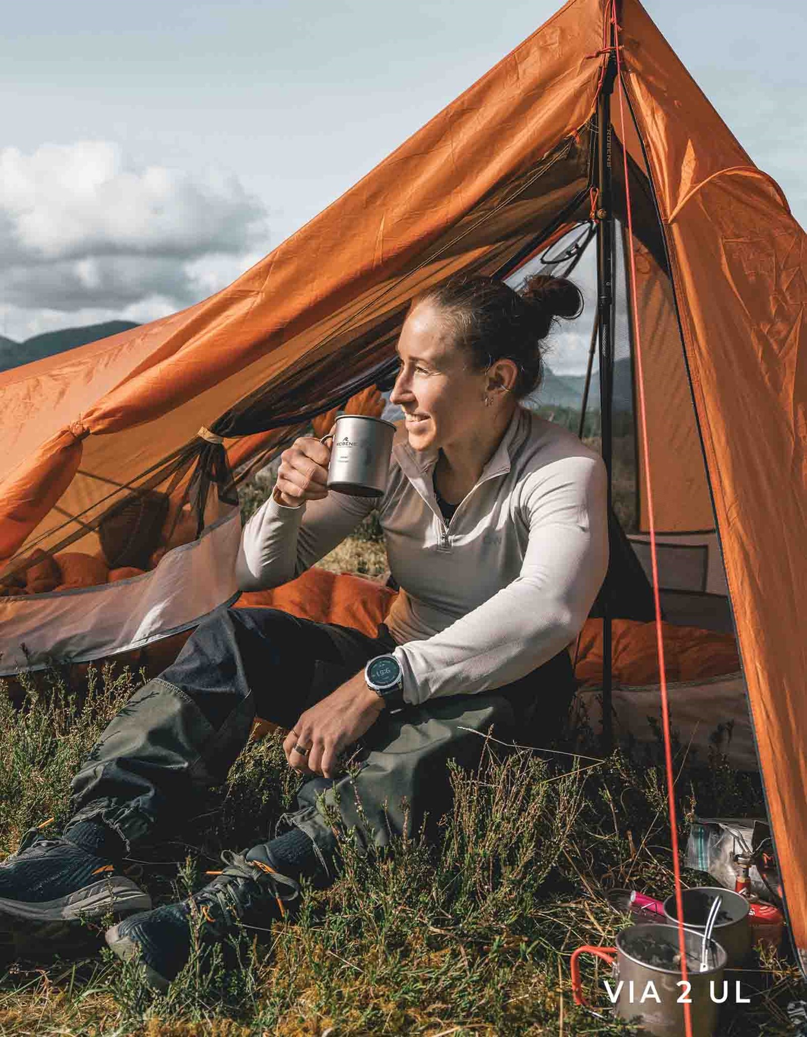 Kvinde der nyder en kop kaffe i sit Via 2 UL telt.