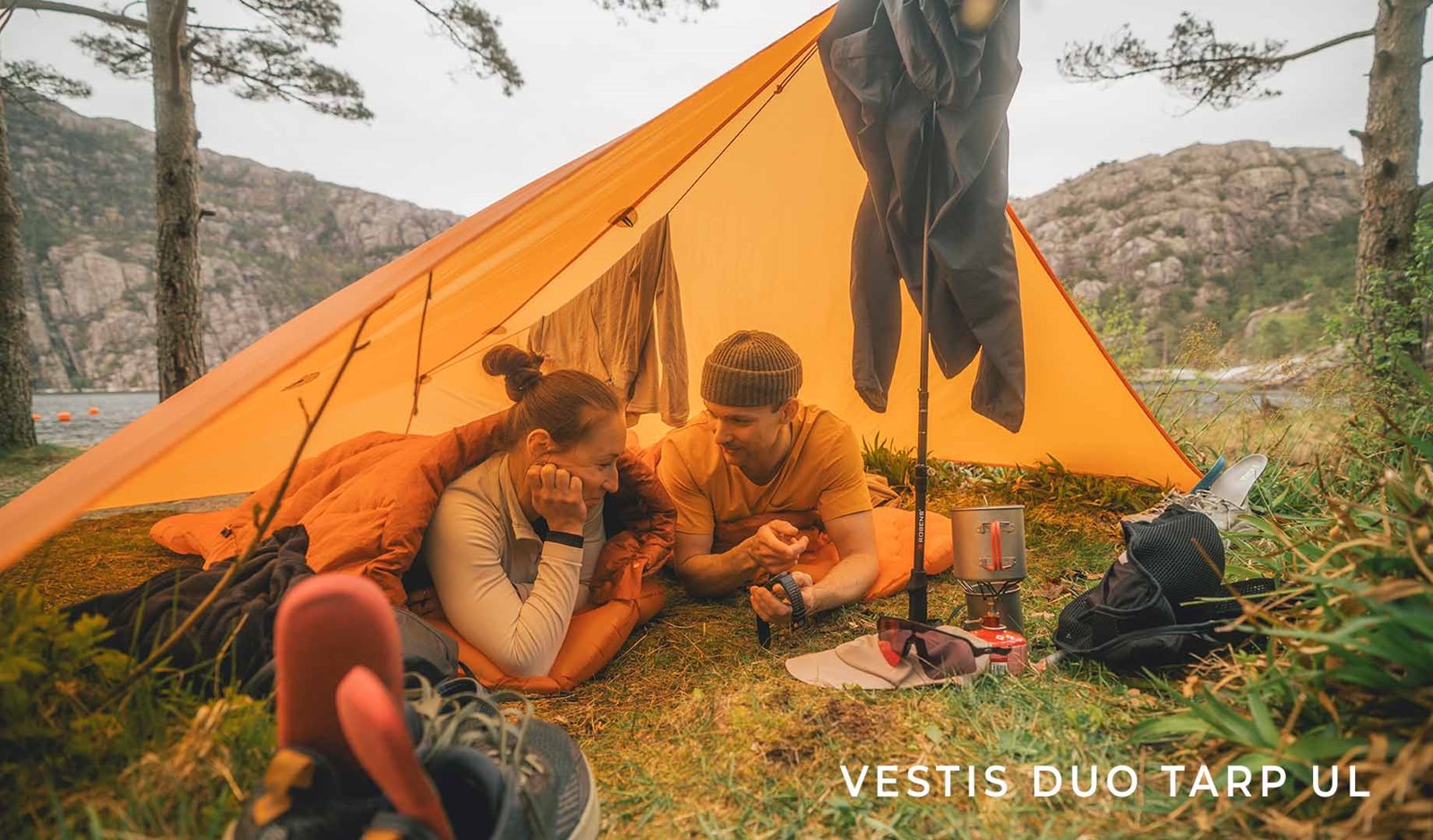 To personer under en tarp i skoven.