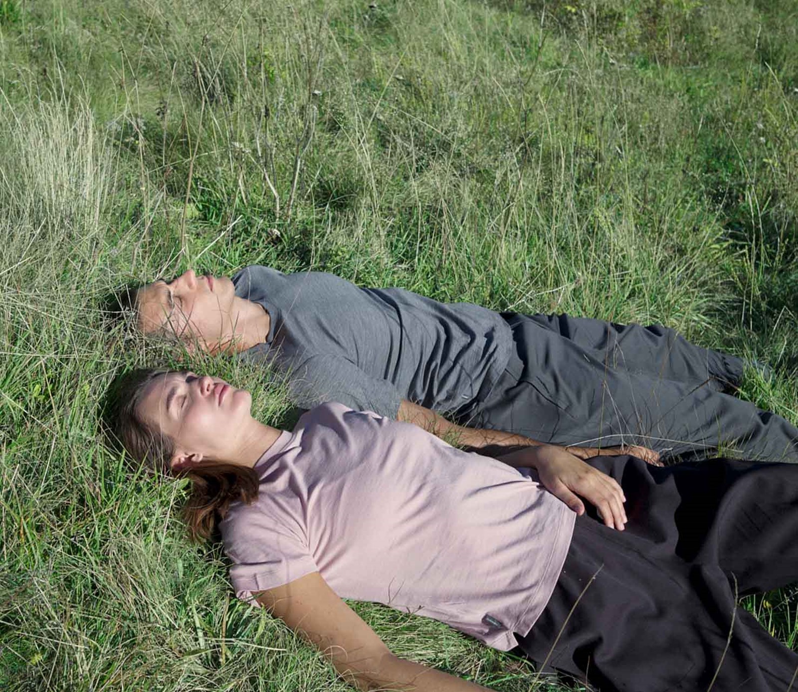 To personer der ligger i græsset med Icebreaker t-shirts.