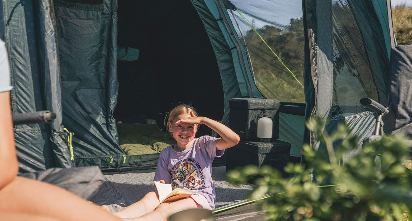 Et barn der læser foran Outwell-teltet.