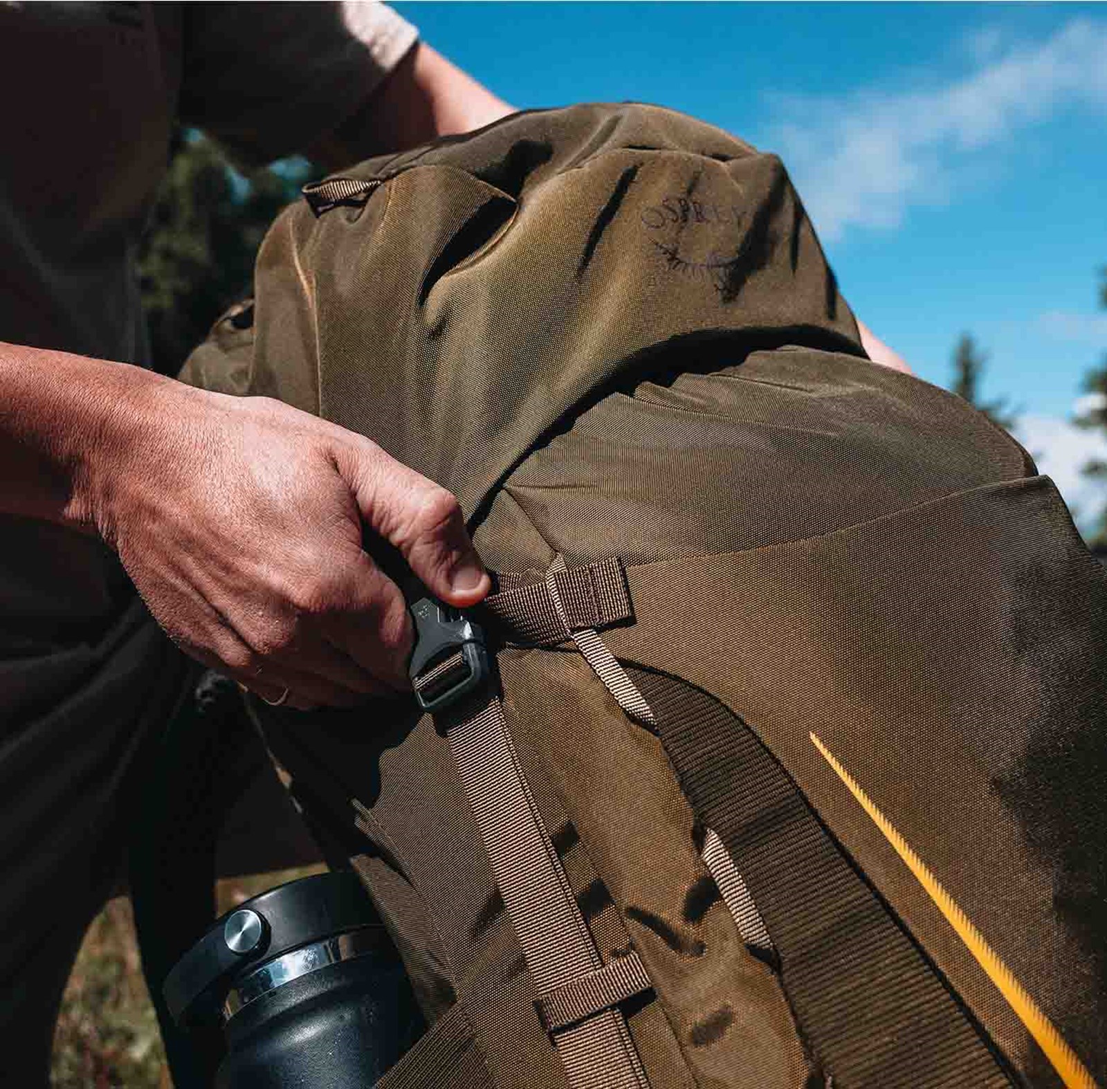Nærbillede af en Osprey rygsæk, der bliver strammet til.
