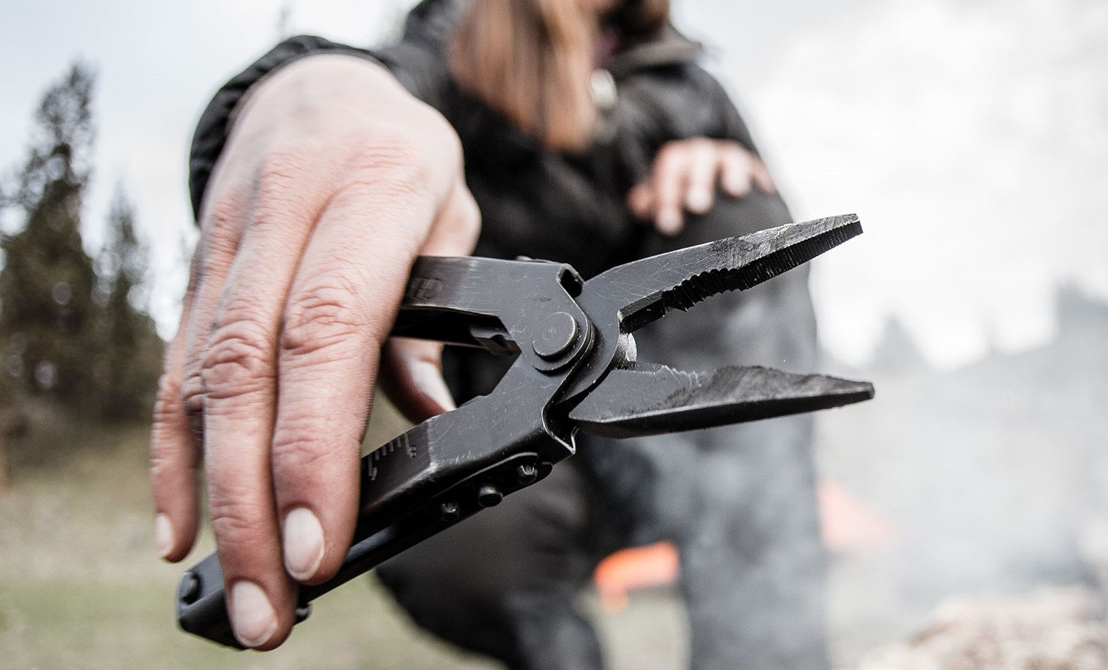 Person, der holder multitool op.